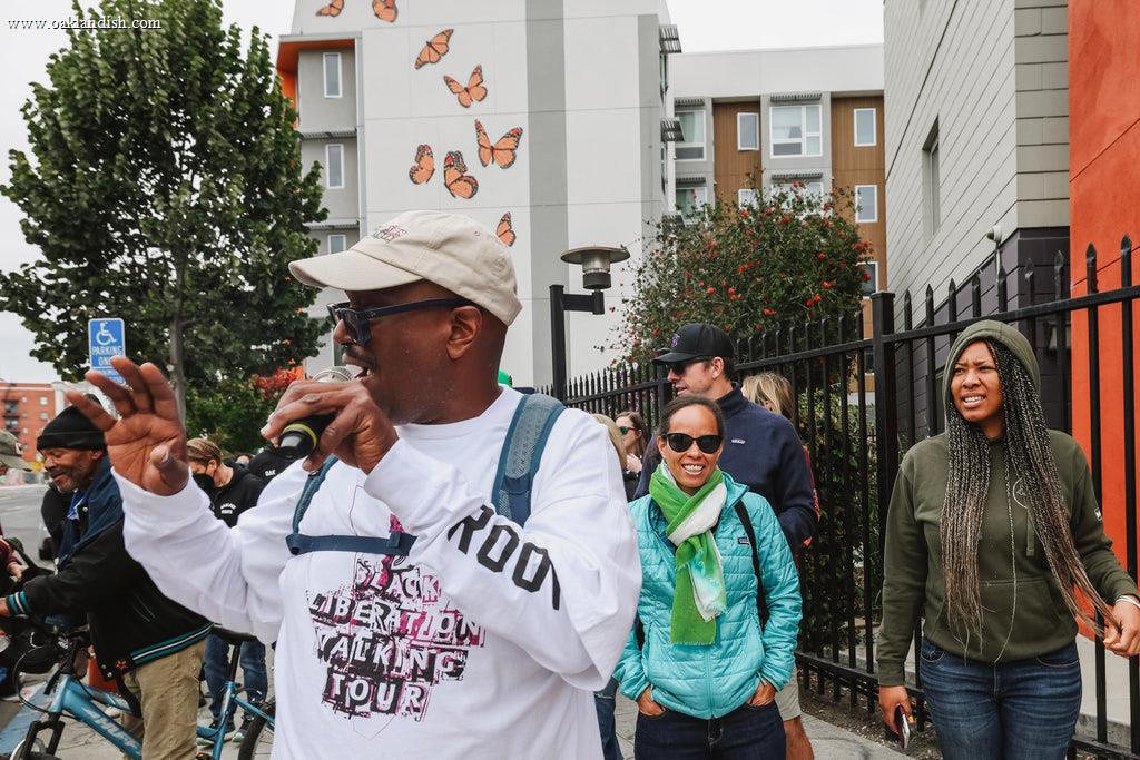 Black Liberation Walking Tour leader speaks to a group of participants while giving a tour outdoors.