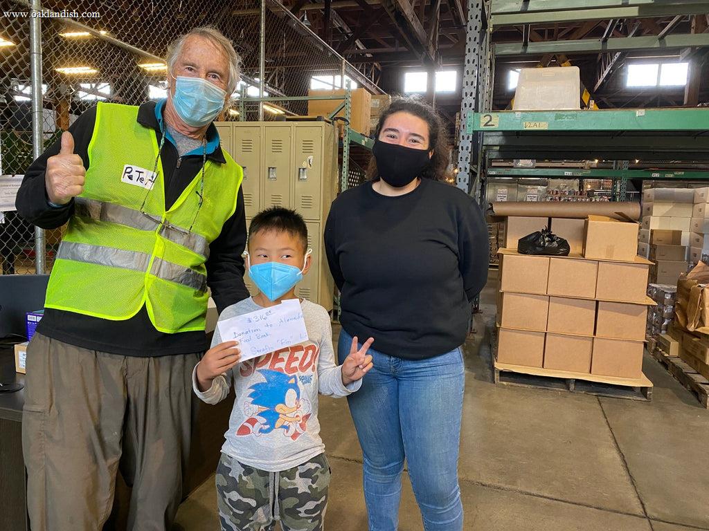 food bank employees in warehouse and kid holding an envelope with donation