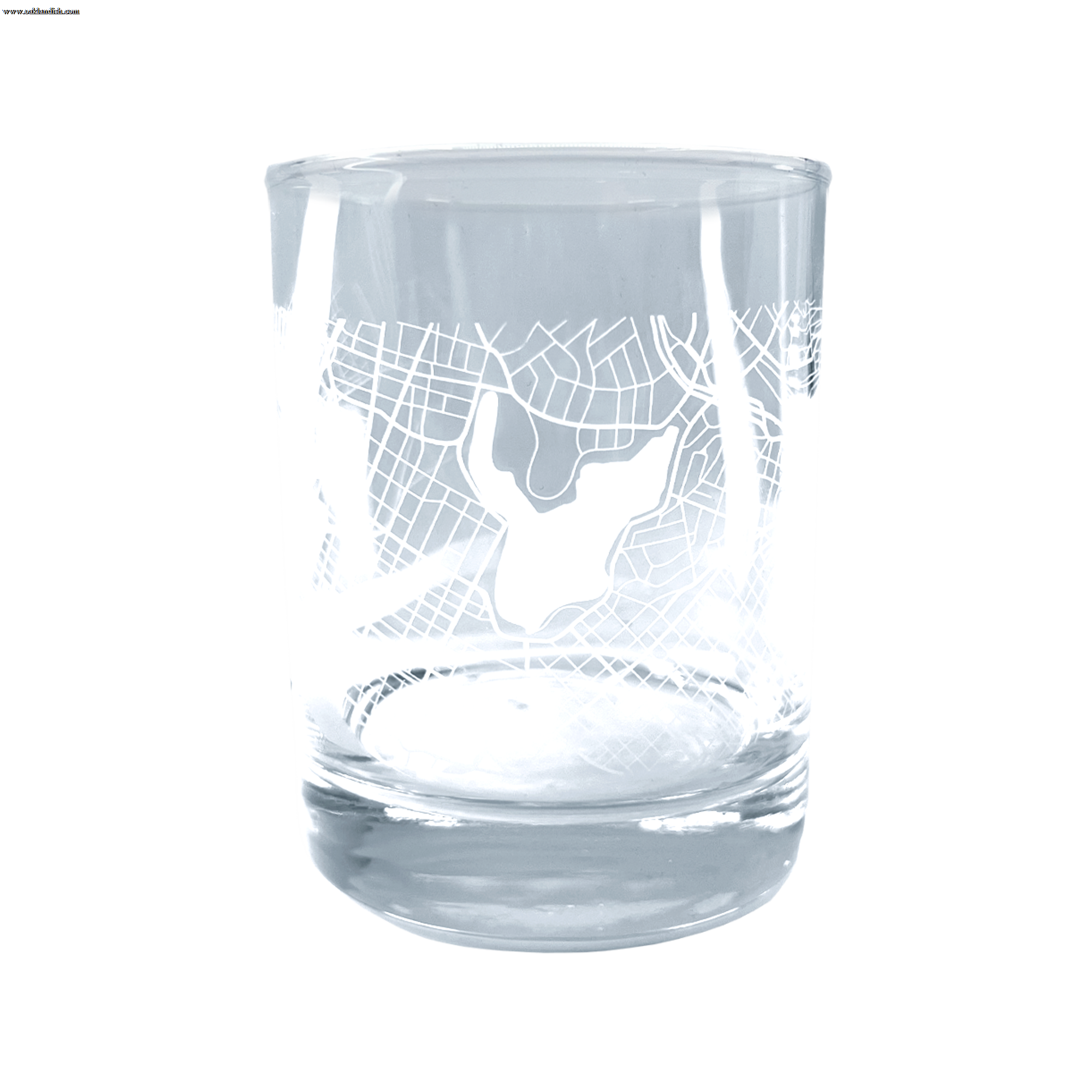 Introducing the Oaklandish Aerial Tumbler, a clear whiskey glass adorned with an intricate etched design that mirrors an aerial map of Oakland. Featuring distinctive lines and a central shape that could indicate a lake or landmark, this classic tumbler boasts a thick base and smooth, cylindrical contour.