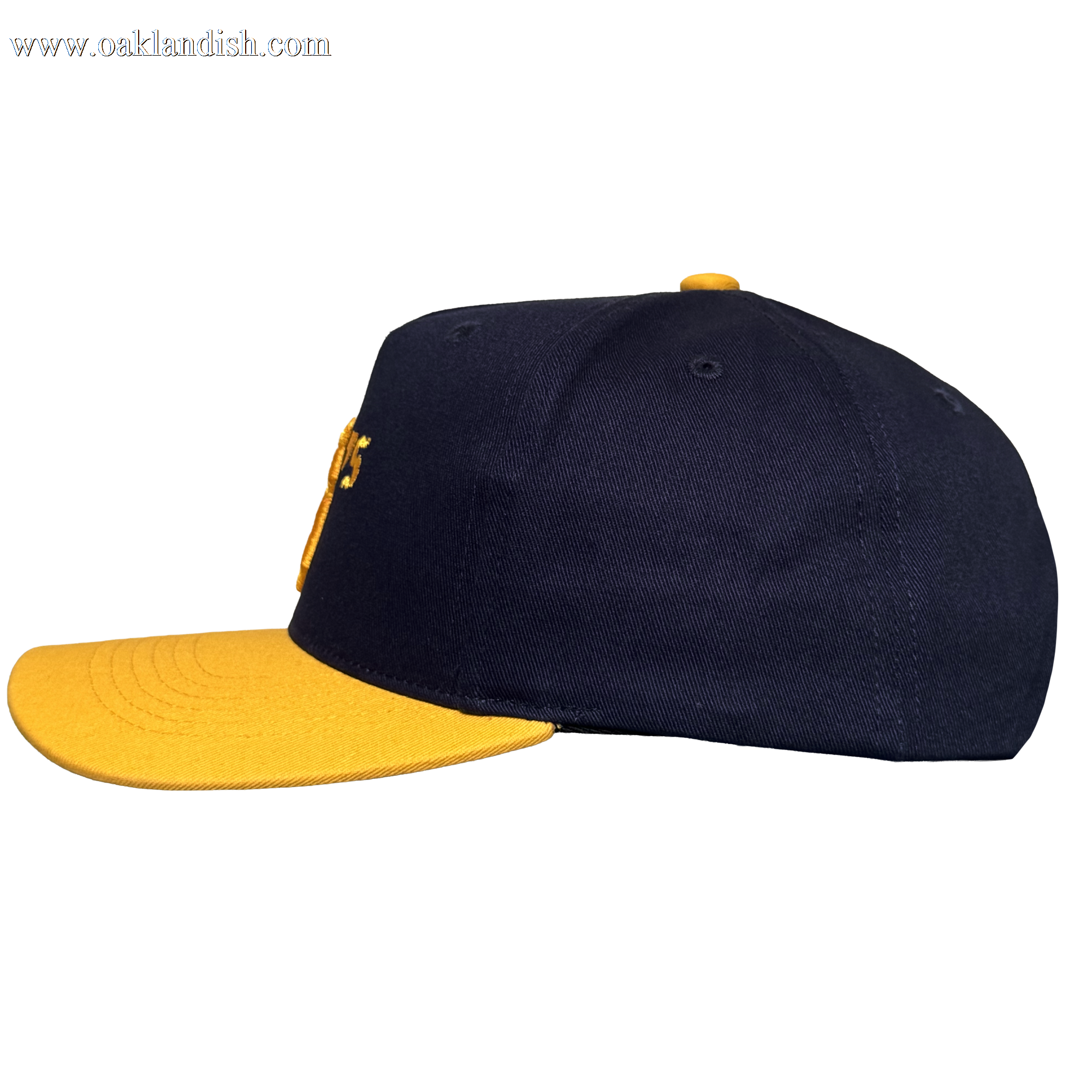 The Oakland Ballers 5 Panel Cap by Oakland Ballers features a navy blue snapback design, flat bright yellow brim, and matching yellow top button. Seen from the side on a white background, partial yellow embroidery appears on the front.