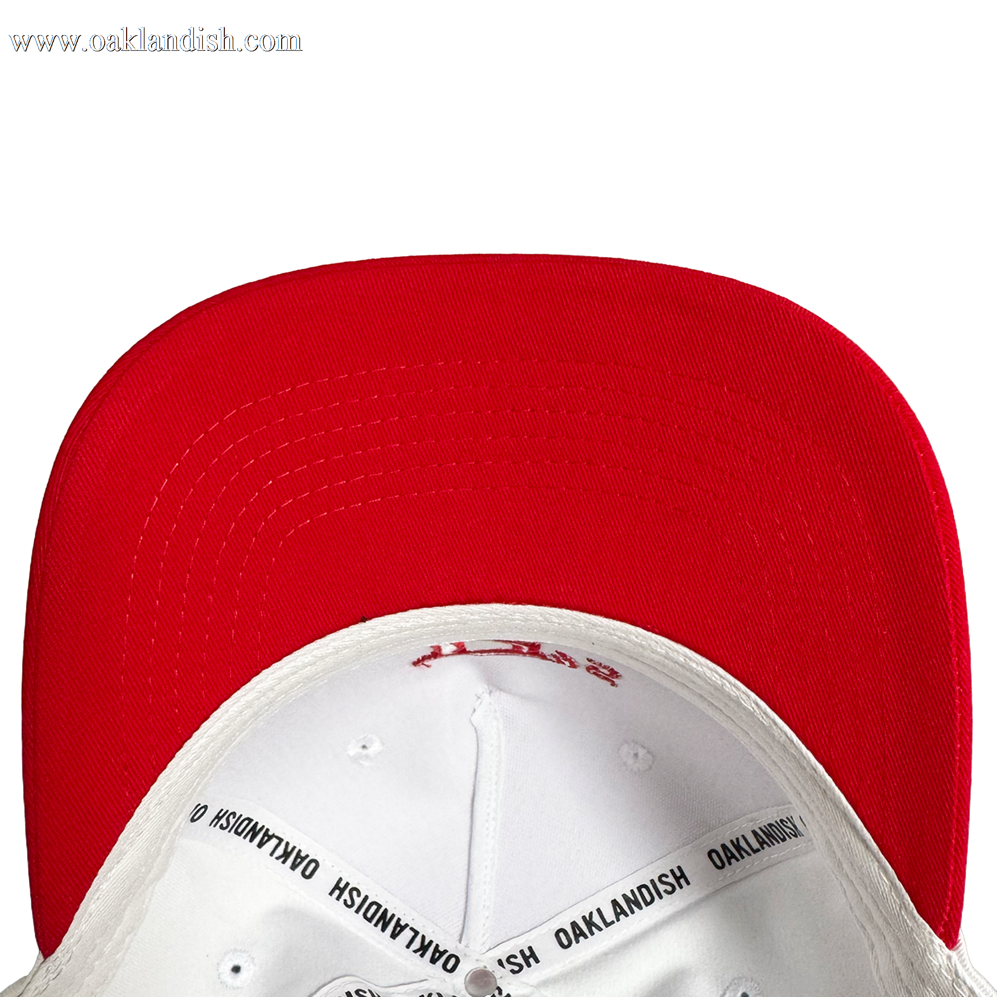 Close-up of the underside of the Oakland Ballers 5 Panel Cap, featuring a red brim and white crown. Black “OAKLANDISH” taping details the interior—a stylish nod to Oakland Ballers baseball. Plain white background.