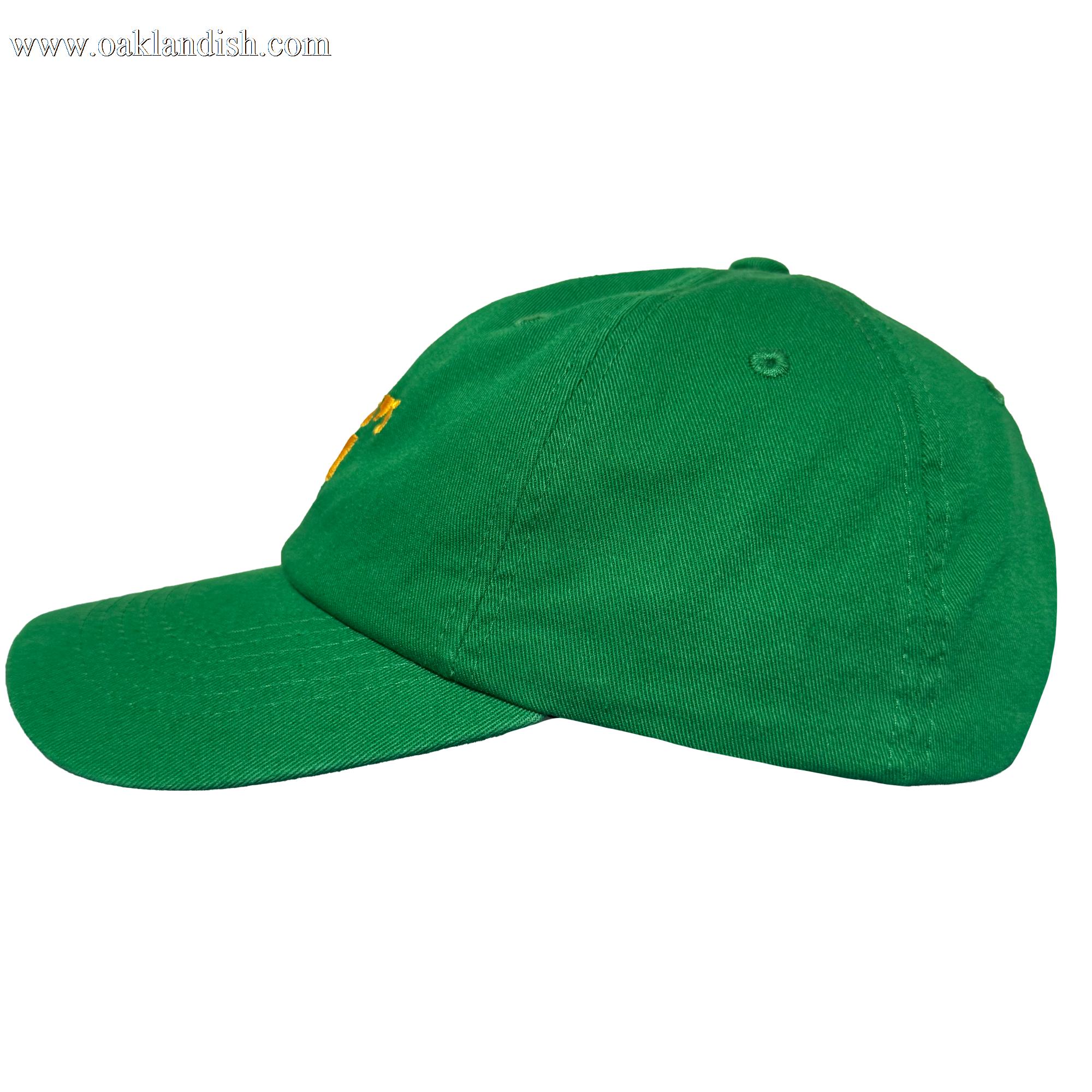The Oakland Ballers Dad Hat features a green design with curved brim, structured panels, and visible stitching. An embroidered yellow accent nods to the Oakland Ballers, with a side eyelet for ventilation. Shown on a plain white background.