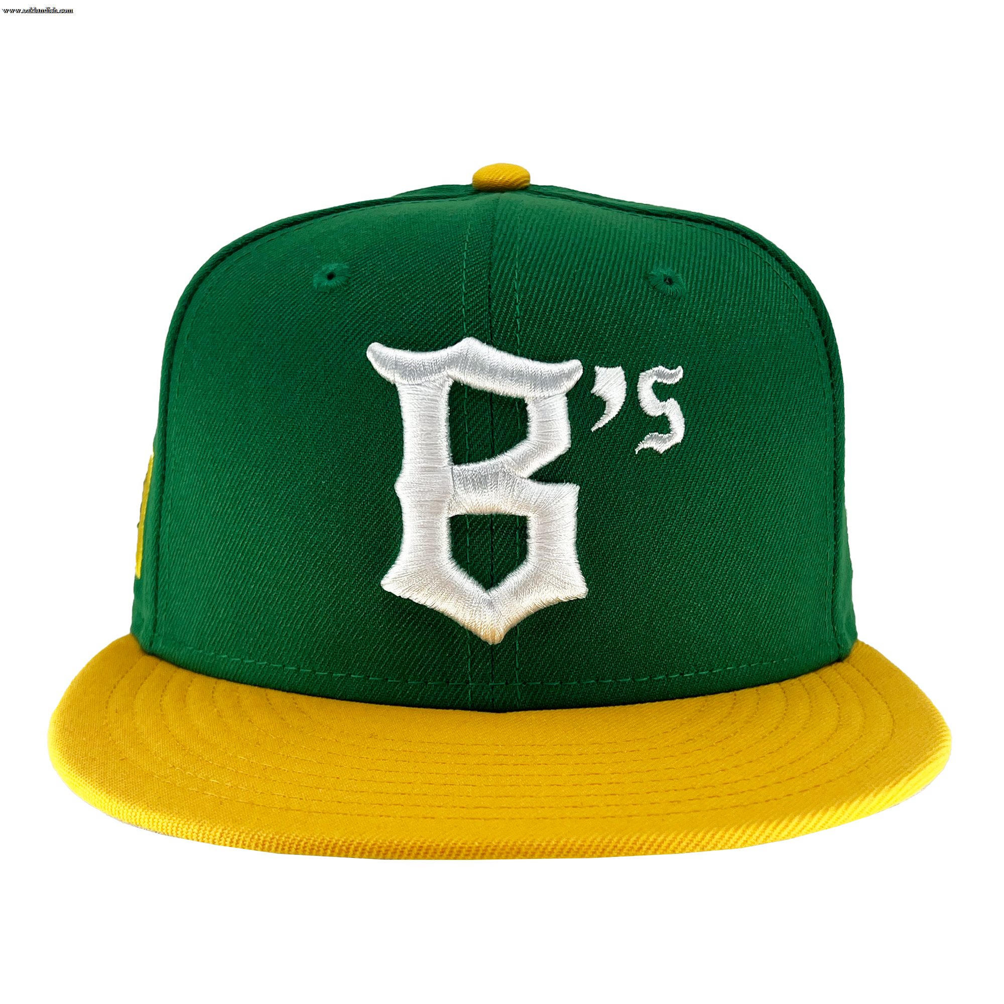 The New Era Oakland Ballers 59Fifty Cap features a green body with a flat yellow brim and a top button that matches in yellow. The front of the cap showcases a white, stylized letter "B" followed by a smaller white "'s," symbolizing the Oakland Ballers. The image background is white.