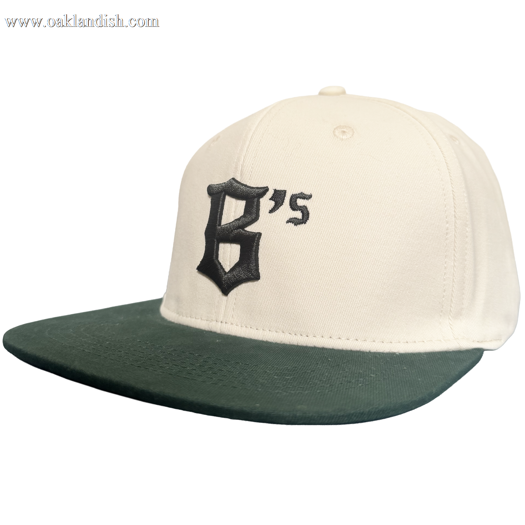 Introducing the Oakland Peloteros Hat by Oakland Ballers: This white cap features a dark green flat brim and showcases a prominent, black Gothic-style "B" with an adjoining apostrophe and "s" on the front—forming "B's," a proud symbol of the Oakland Ballers team from the Pioneer League. The background is crisp, clean white for a classic appeal.