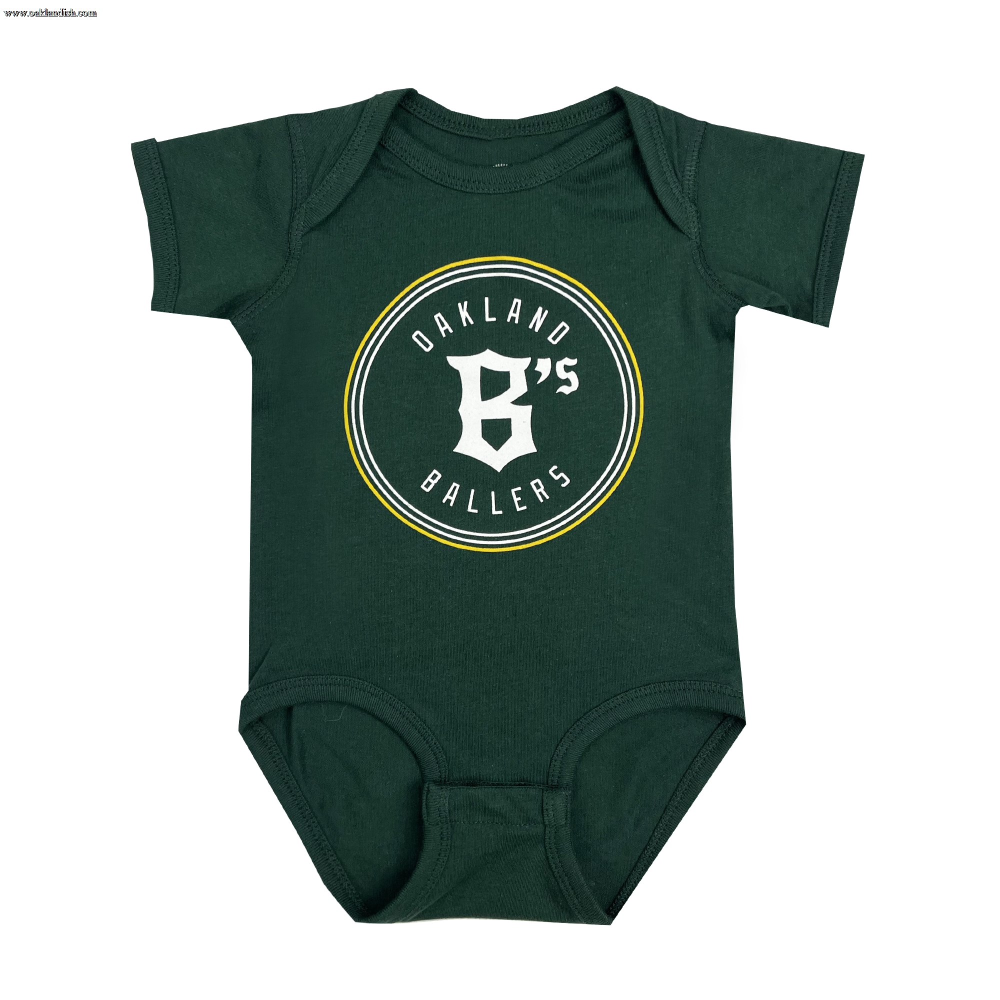 The Infant Oakland Ballers Logo One-Piece is a small, green baby onesie with short sleeves. The front showcases the "OAKLAND B'S BALLERS" logo, emphasizing their West Coast franchise. The logo features thin yellow, gray, and white concentric circles. For convenience, the onesie includes two snaps on each shoulder and three snaps at the bottom for easy dressing.