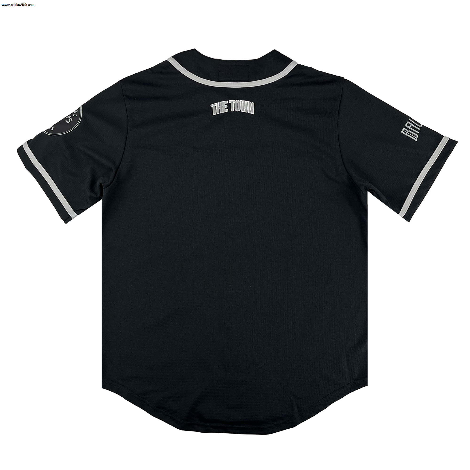 The Oakland Ballers Button Up Jersey by Oakland Ballers features "THE TOWN" on the upper back, white-trimmed sleeves, a patch on the left sleeve, and Oakland Ballers team lettering on the right sleeve. Shown from the back on a white background.