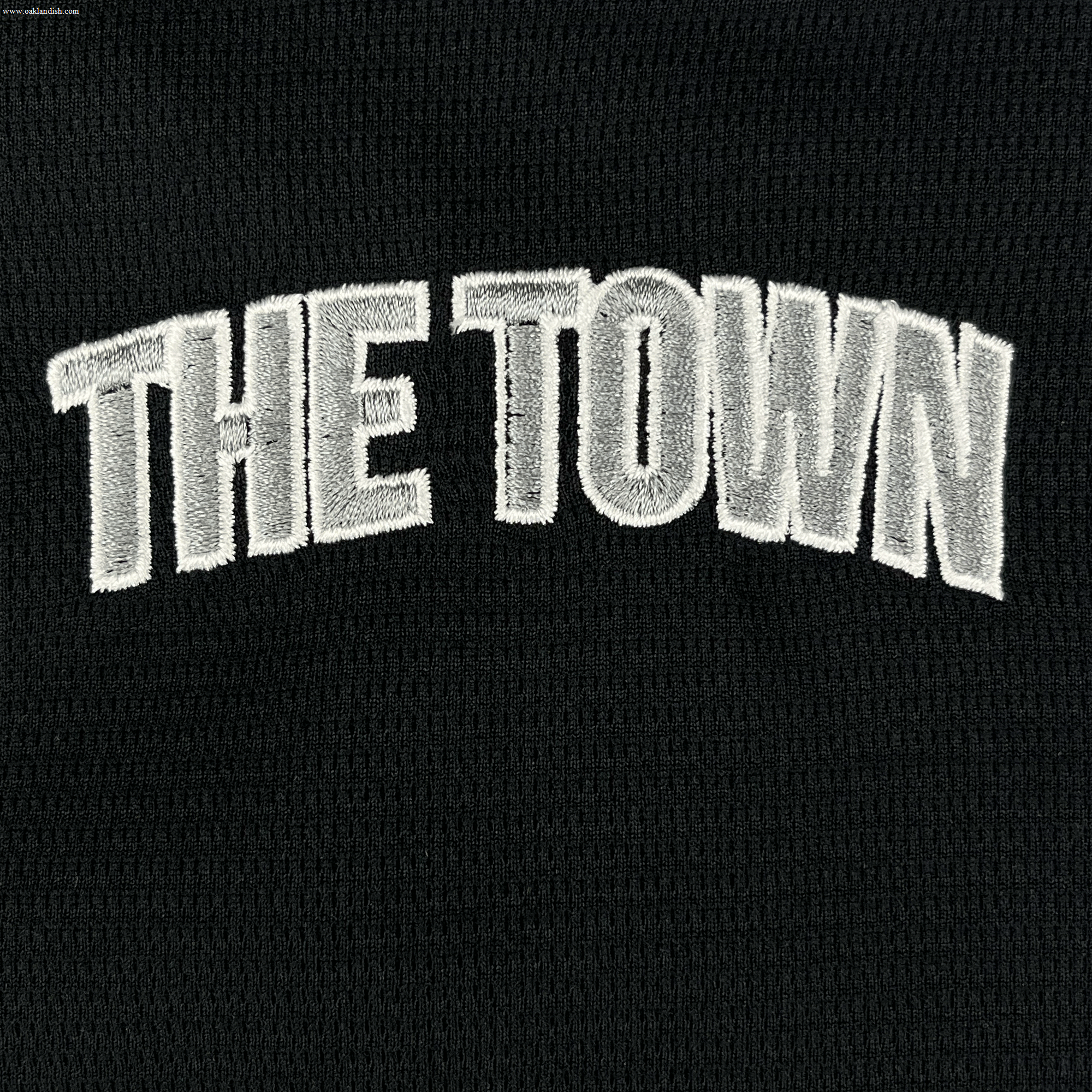 The Oakland Ballers Button Up Jersey features "THE TOWN" embroidered in bold white letters on black fabric, honoring the Oakland Ballers, a Pioneer League pro baseball team, with text arched across the center.