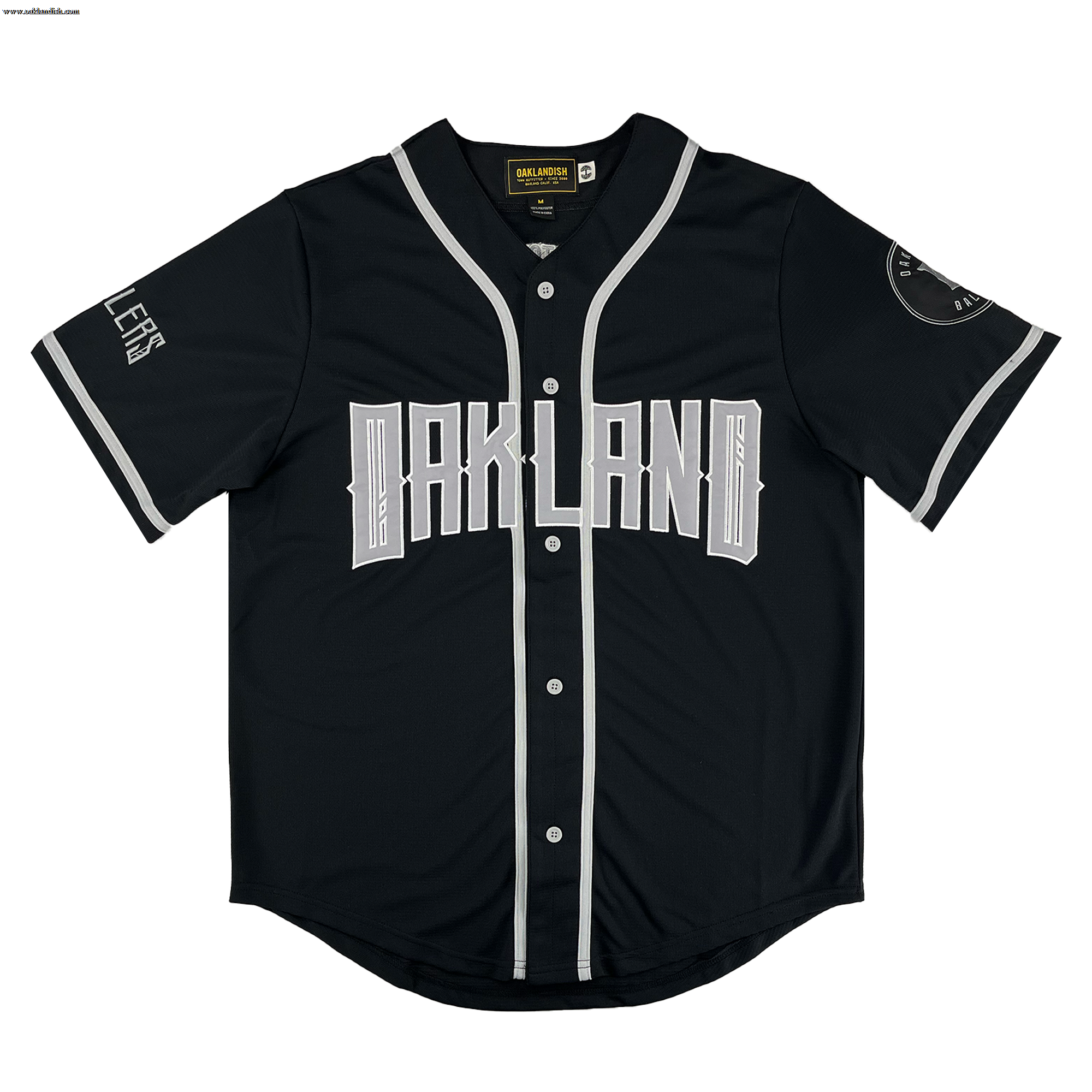 The Oakland Ballers Button Up Jersey by Oakland Ballers features a black design with white buttons, sleeve, and collar trim. "OAKLAND" is boldly printed across the chest, representing the Pioneer League baseball team. White details accent sleeves and cuffs.