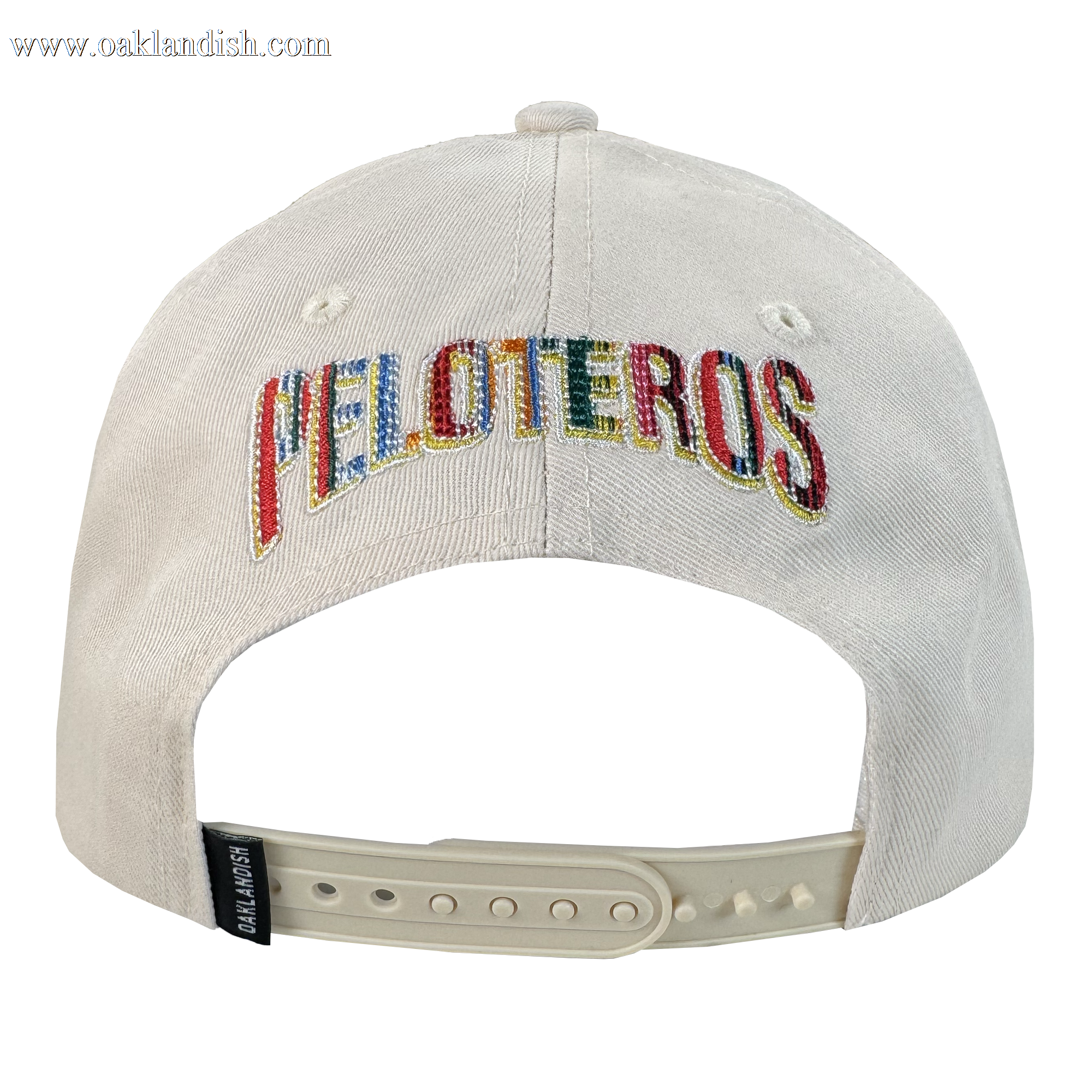 The Oakland Beisbol 5 Panel Cap by Oakland Ballers is a white snapback shown from the back with "PELOTEROS" in multicolored thread, an adjustable white plastic strap, and a black "CAP SLAM USA" tag on the side.