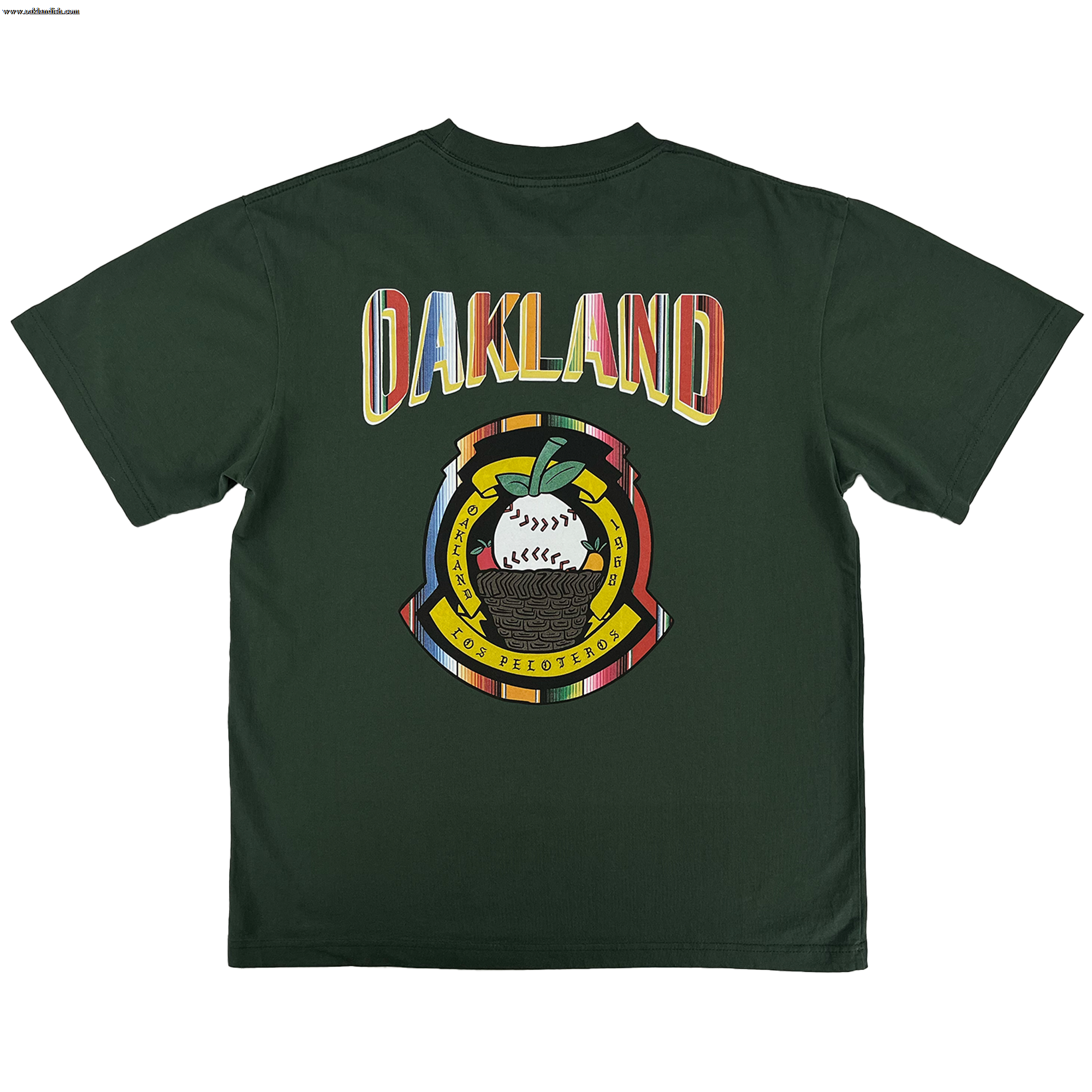 The Oakland Beisbol Tee by Oakland Ballers features a dark green design with bold “OAKLAND” in retro font on the back, plus a circular emblem below with a baseball, oak leaf, “LOS PELOTEROS,” and Pioneer League–inspired details.
