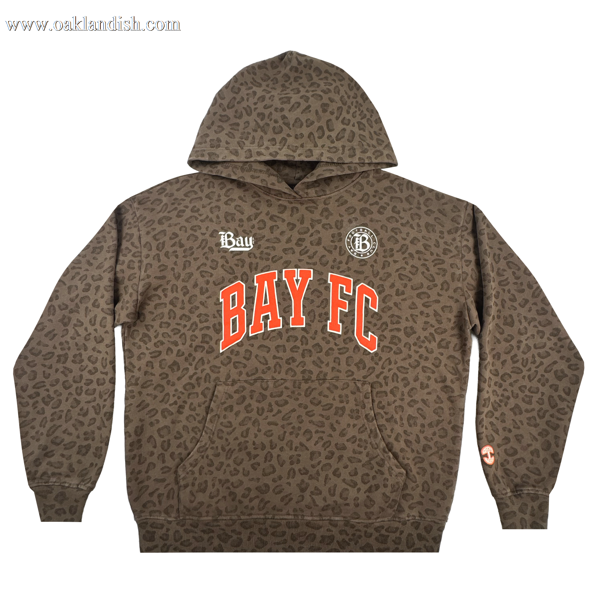 The Bay FC Leopard Hoodie features a brown pullover design with an all-over Leopard Camo print, bold red and white "BAY FC" across the chest, two white logos above, and a small orange symbol on the left sleeve near the wrist.