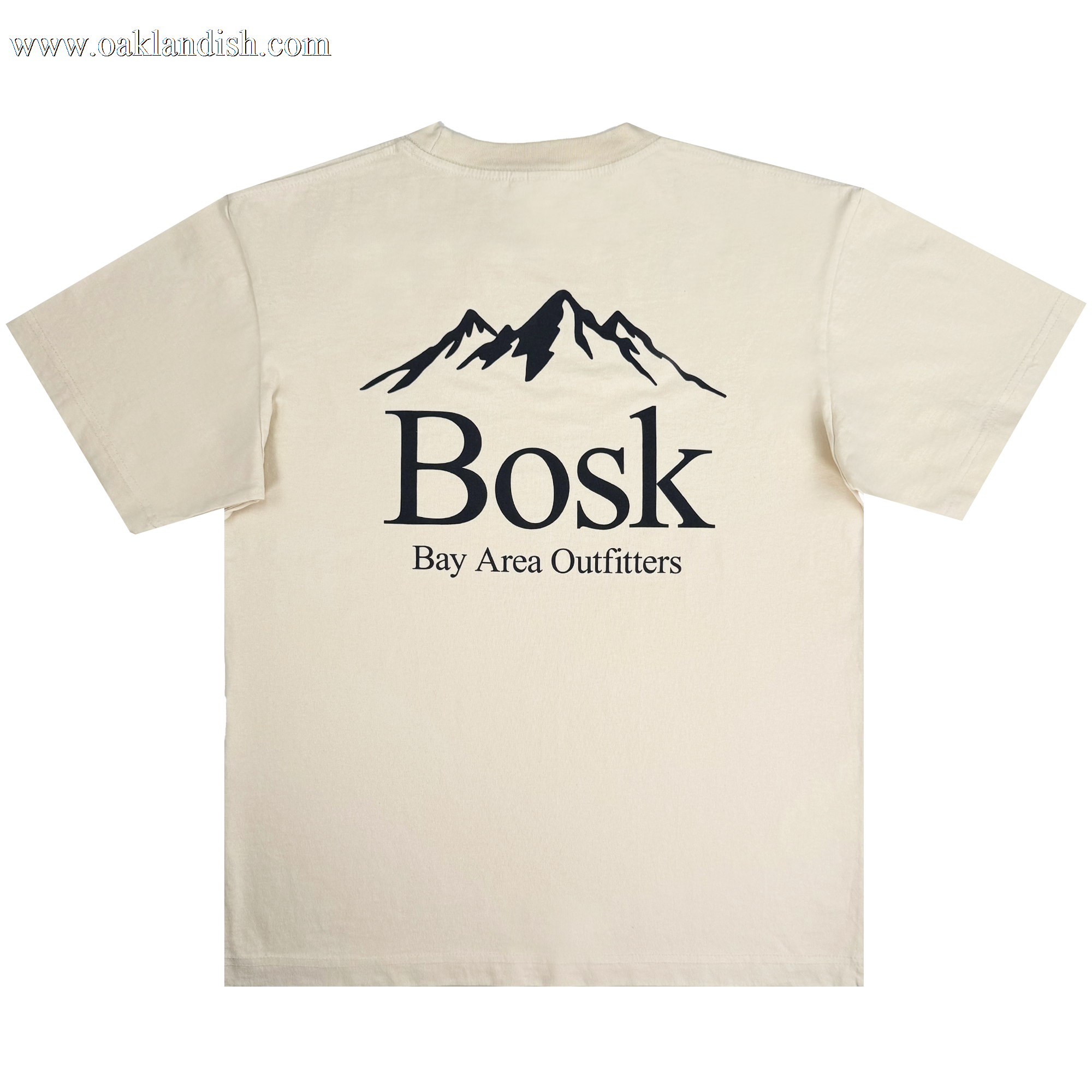 The Bosk Outdoors Tee by BOSK is a beige heavyweight cotton t-shirt with a black mountain graphic on the upper back, "Bosk" in bold below, and "Bay Area Outfitters" in smaller capitals. Designed for men's oversized fit, it's shown against a plain white background.