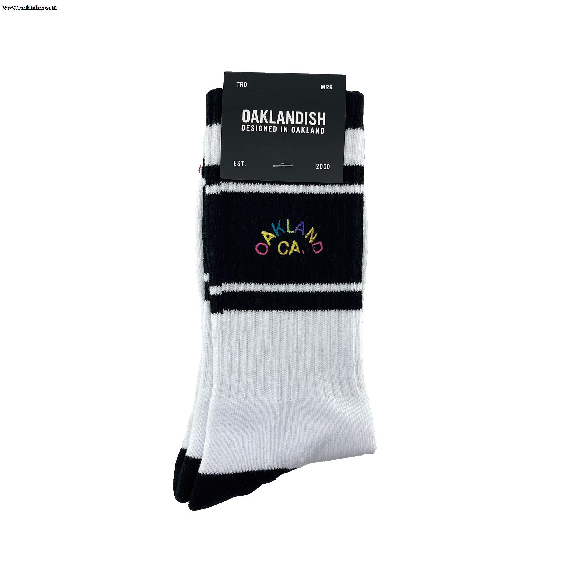 Pair of folded black and white crew socks in Oaklandish packaging with full-color OAKLAND CALIFORNIA wordmark on the sock.
