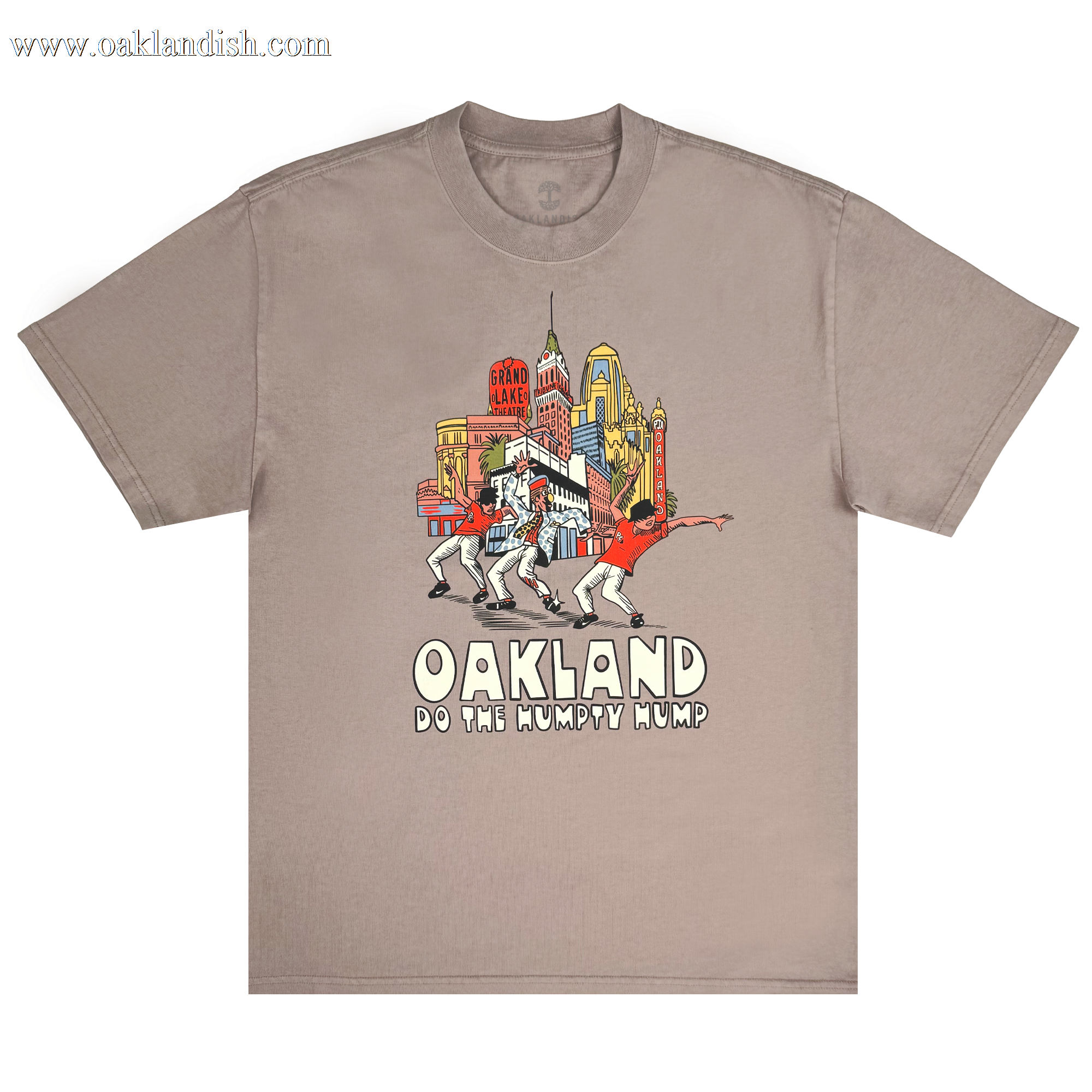 The Do the Humpty Hump Heavy Tee by Oaklandish showcases a taupe shirt with iconic Oakland landmarks and palm trees. It features four dancers performing the "Humpty Hump" as a tribute to Digital Underground, with "OAKLAND DO THE HUMPTY HUMP" in stylized font.