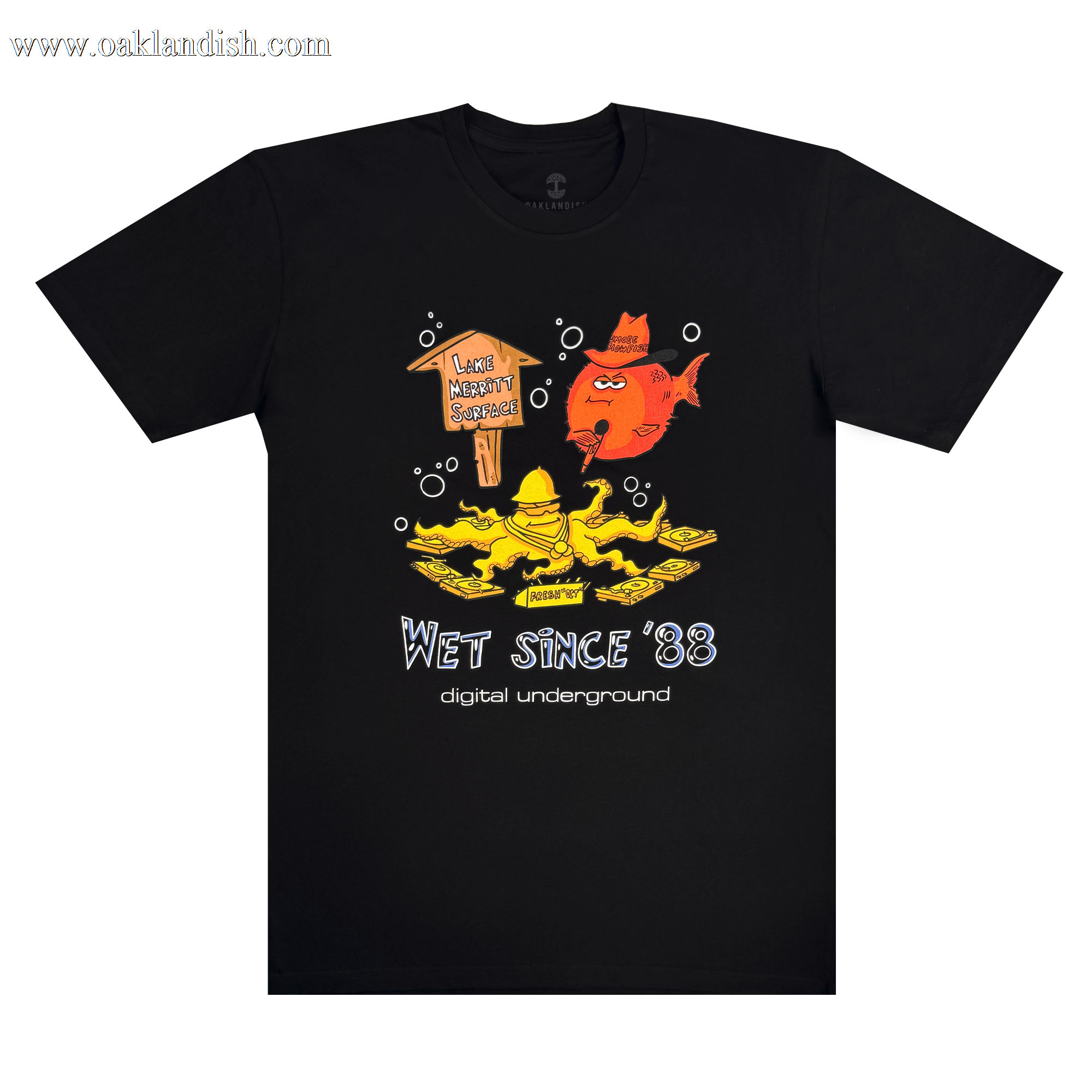 The Wet Since '88 Tee from Oaklandish features a cartoon yellow figure playing saxophone on a floating platform with "I Love Money So Much," accompanied by a red-hatted fish above. The design celebrates "Digital Underground" and Oakland roots, channeling the spirit of "Underwater Rimes.