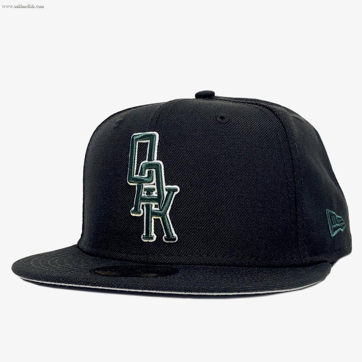 The New Era OAK 59FIFTY Fitted Cap by Other features a black design with “OAK” embroidered in green and white on the front panel. The left side showcases the New Era logo stitched in green. The cap is displayed against a plain white background.