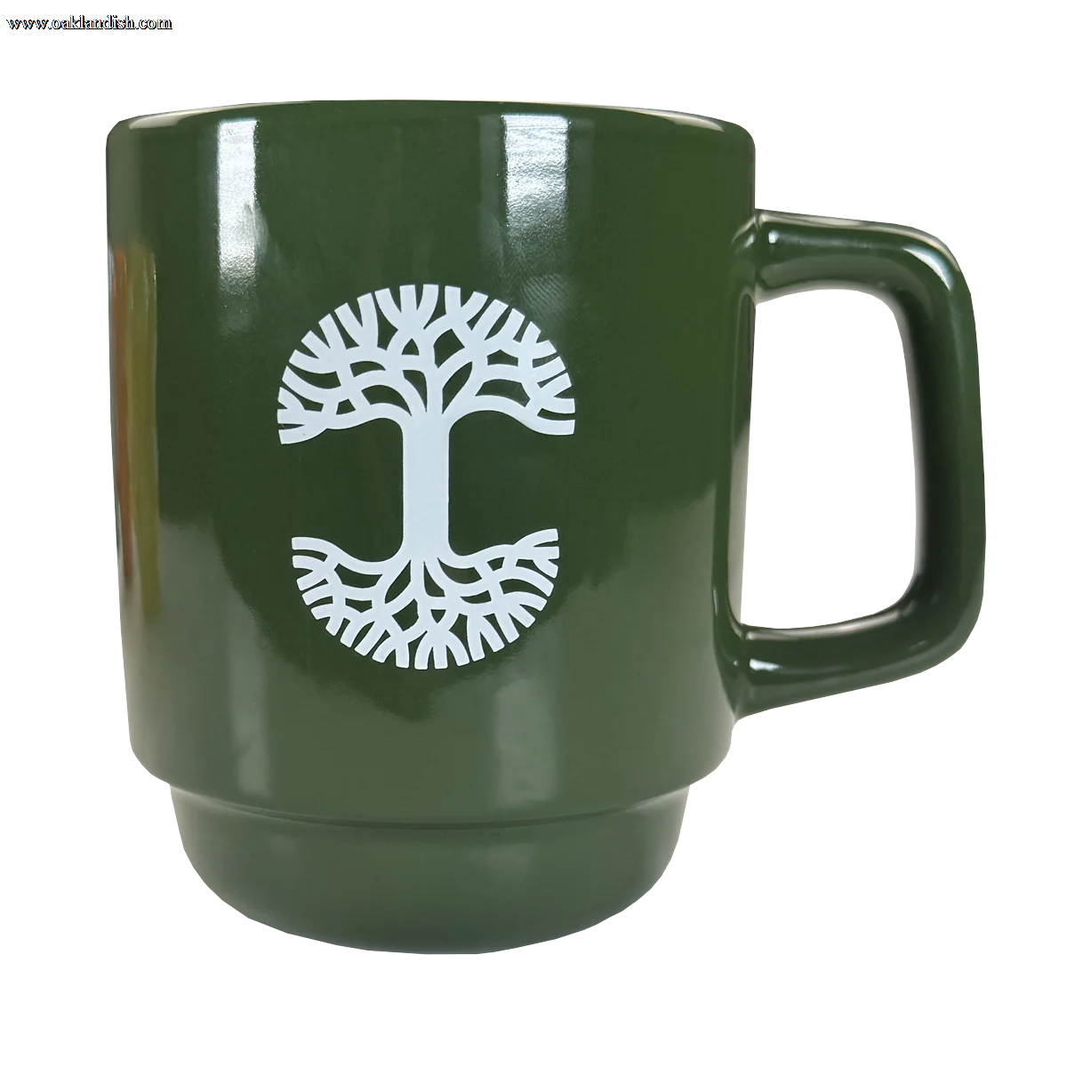 The Oaklandish Logo Stack Mug is a glossy green ceramic mug with a large handle and a white tree design. Its mirrored branches and roots stand out, while the stackable design adds style and practicality. Perfect for any kitchen.