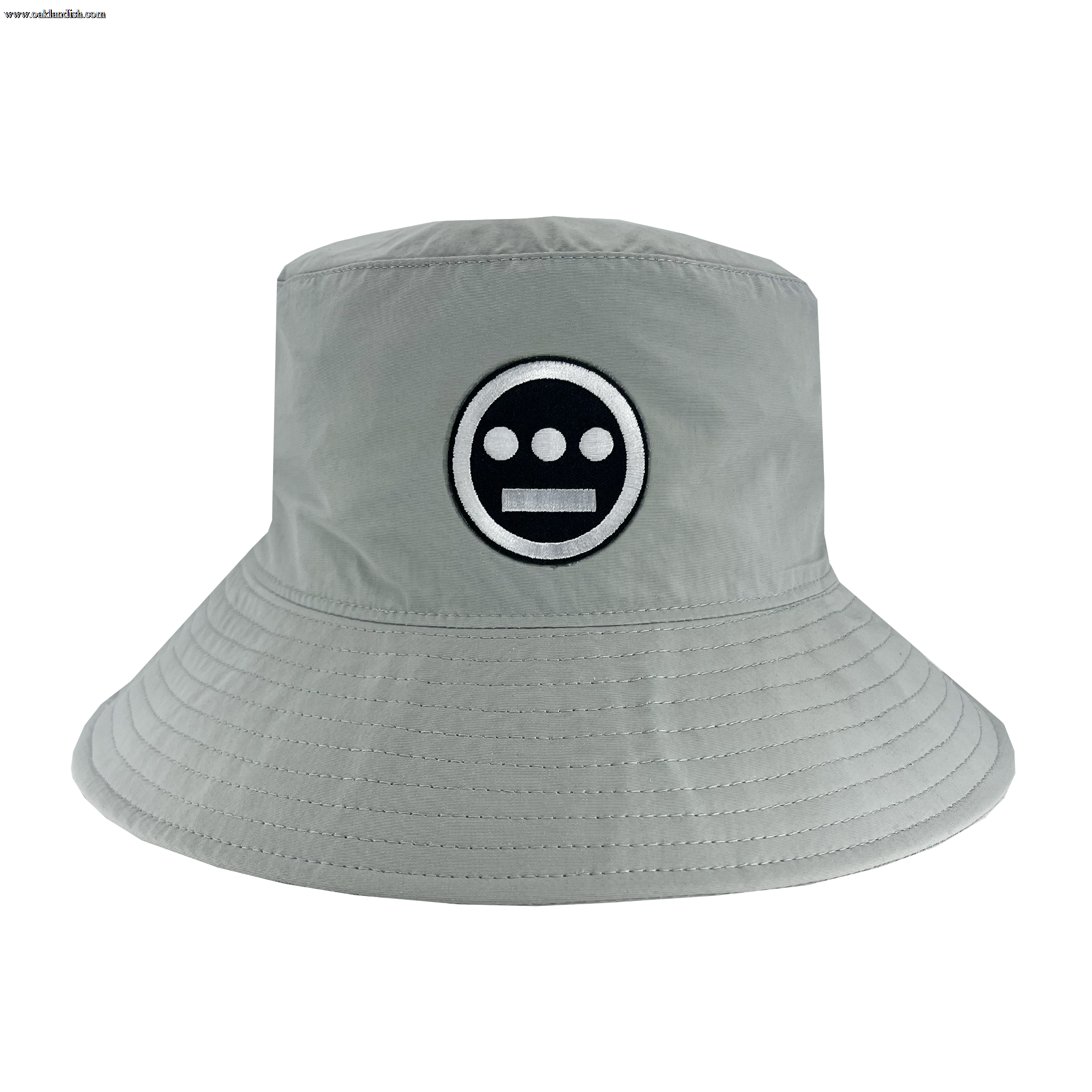 The Hiero Boonie Hat by Hieroglyphics is a light gray bucket hat crafted from recycled nylon, featuring a black and white embroidered logo on the front. The logo includes a black circle with three horizontal white dashes and a solid white line. The hat has a downward-sloping brim with visible stitching around the edge, evoking modern hieroglyphics.