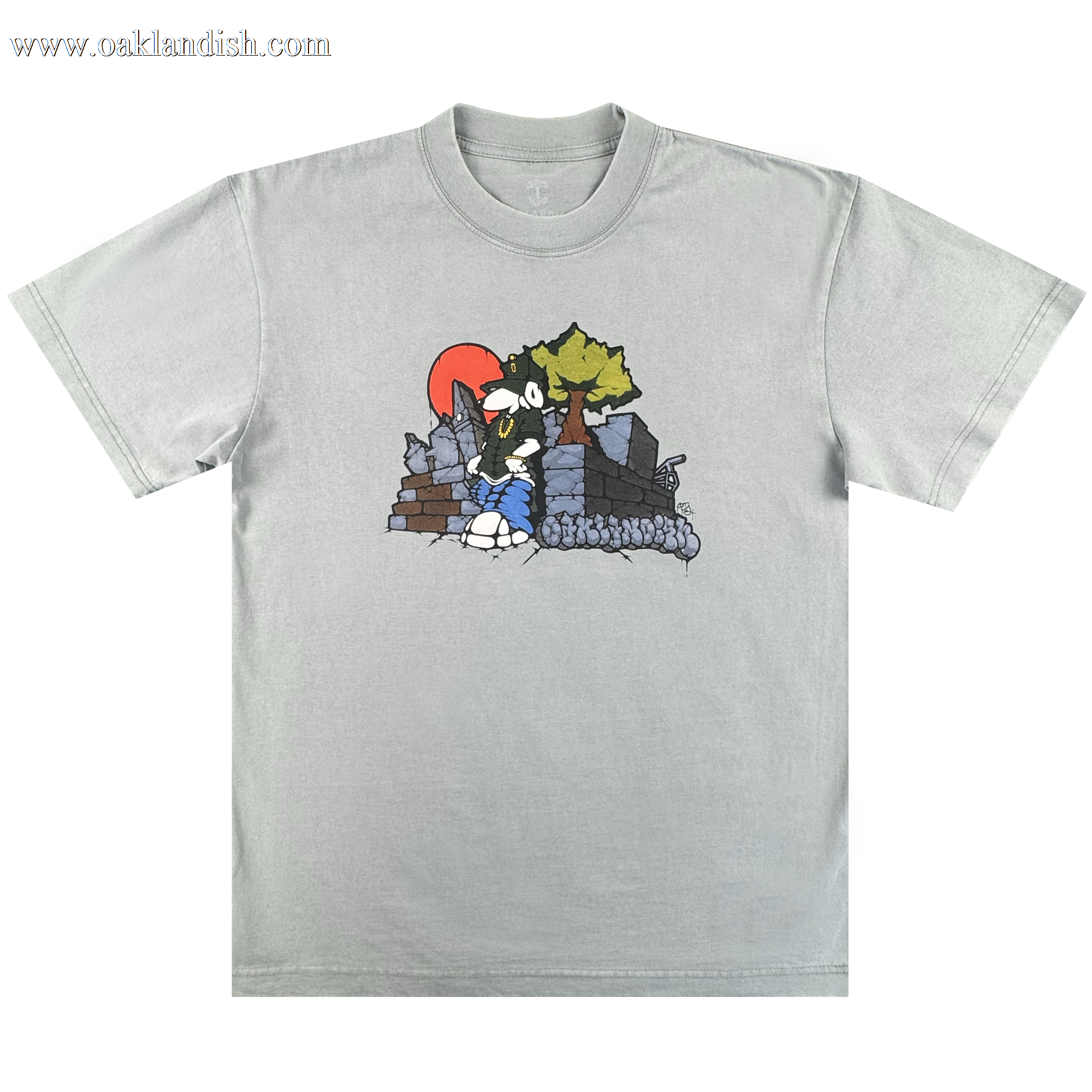 The Oaklandish Highroller Tee is a vintage grey heavy-weight cotton shirt with a cartoon-style black-and-white wolf by ruins and a tree, set against an orange-red sun. The classic fit design is centered on the chest for a timeless look.