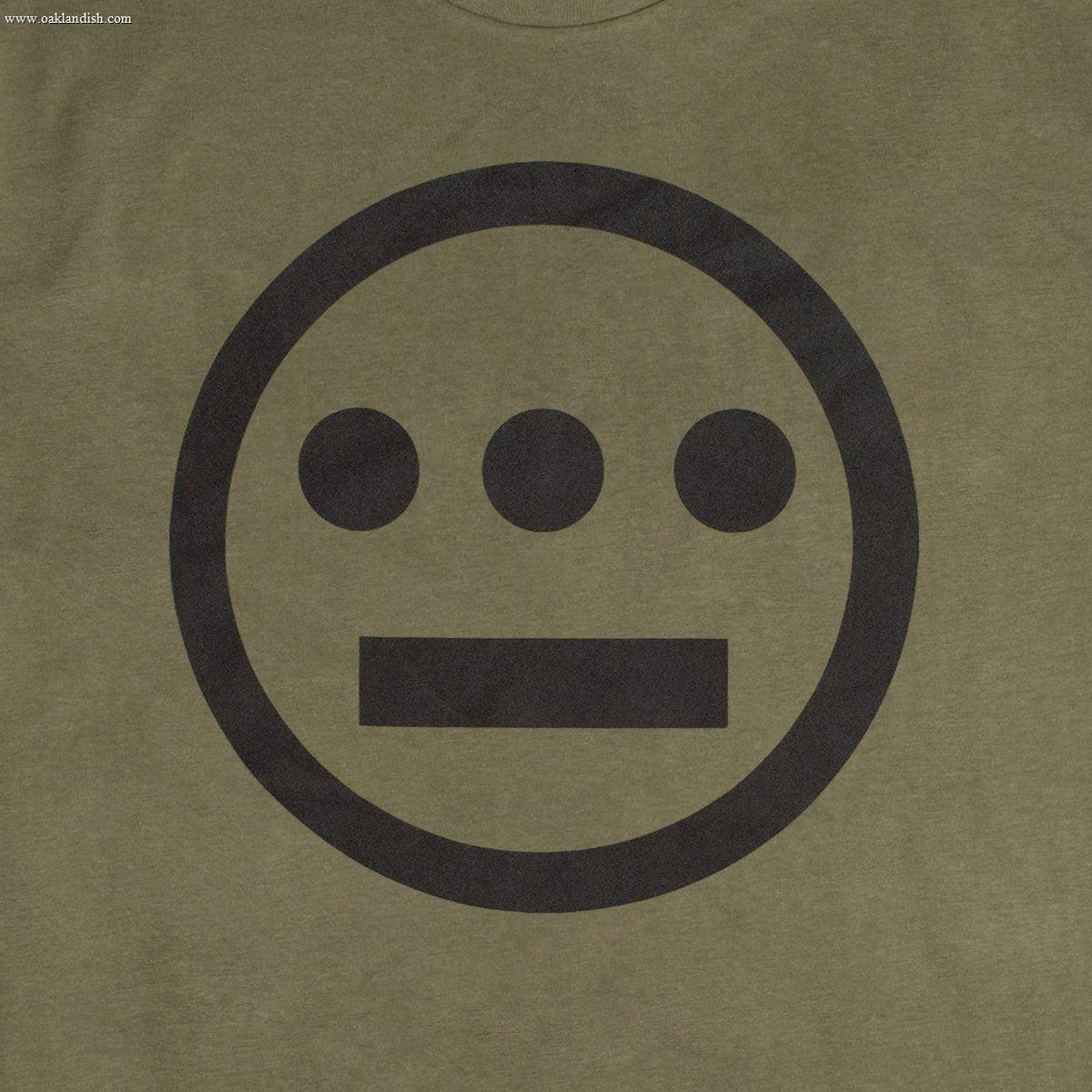 The Hieroglyphics brand's Hiero Classic Logo Tee is an olive green, 100% cotton t-shirt that features a minimalist design centered on the front. The large, black circular emblem contains three black dots aligned horizontally at the top and a horizontal black line below them, resembling hieroglyphics. This classic fit tee offers both style and comfort.