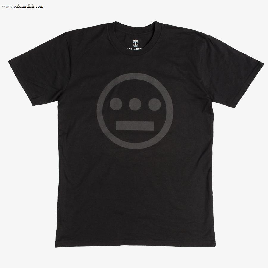 The Hieroglyphics Hiero Classic Logo Tee is a black T-shirt that showcases a subtle, dark gray logo of an outlined circle containing a horizontal line above three dots, resembling a hieroglyphic face. The logo is centrally placed on the chest area. This hip-hop-inspired T-shirt features a crew neck and short sleeves.