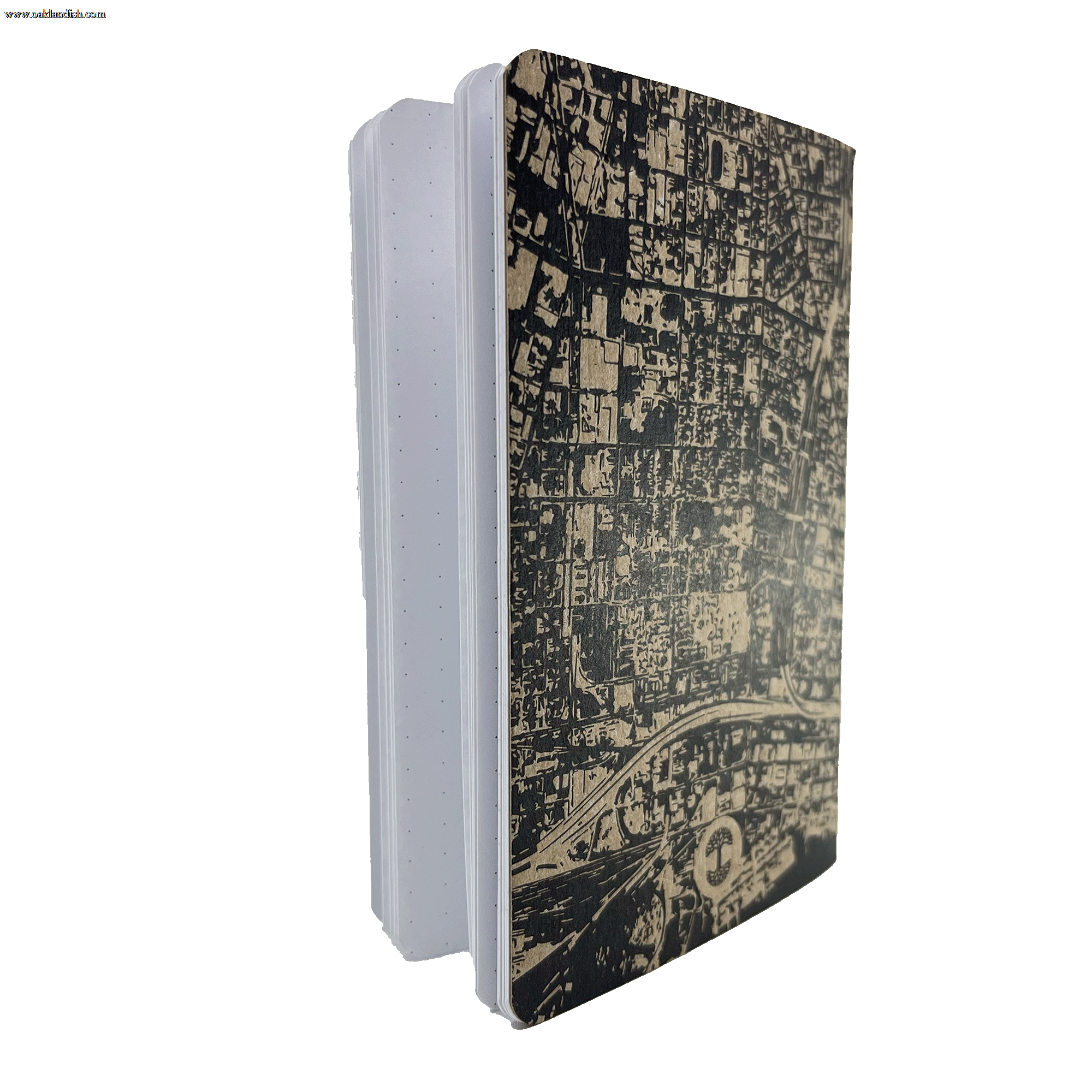 The Aerial Map Mini Notebook by Never Elsewhere is displayed standing upright with its pages slightly fanned out. This mini hardcover notebook boasts a stylish black and white city map design on the letterpress cover, rounded corners, and dot grid paper inside, offering an ideal layout for diverse writing needs.