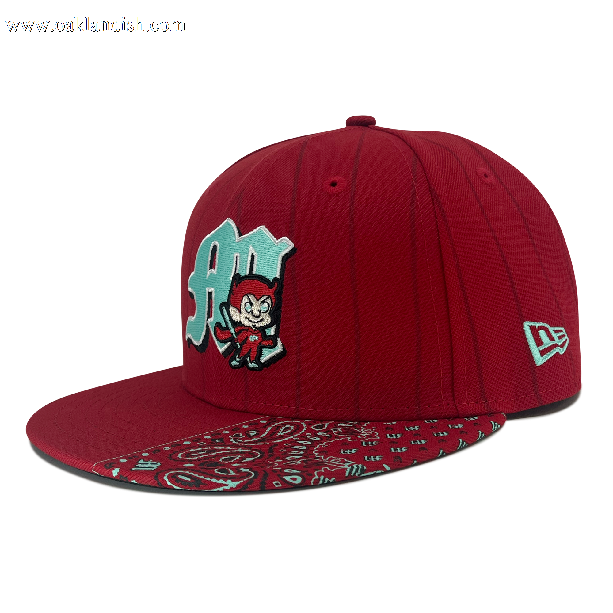 The New Era Diablos Pinstripe 59FIFTY Cap from Other features a vibrant red fitted design with vertical pinstripes. The front is adorned with a light blue “A” and a cartoon devil graphic, while the flat brim displays an eye-catching red and blue paisley bandana pattern. The cap is finished with the classic white New Era logo embroidered on the side.