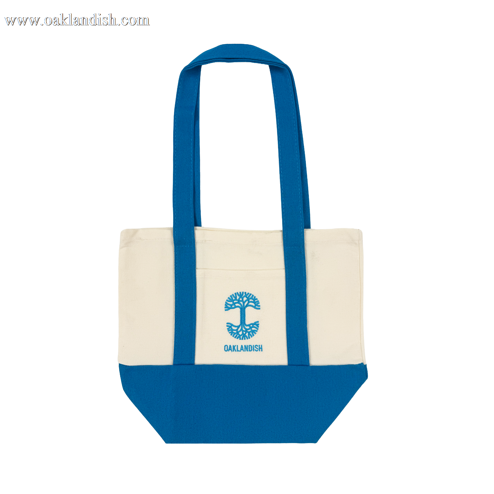 The Oaklandish Mini Grocery Tote features a cream upper, bright blue bottom, handles, and trim. Centered on the front is an embroidered blue tree logo above "OAKLANDISH." Spacious main compartment stores your essentials.