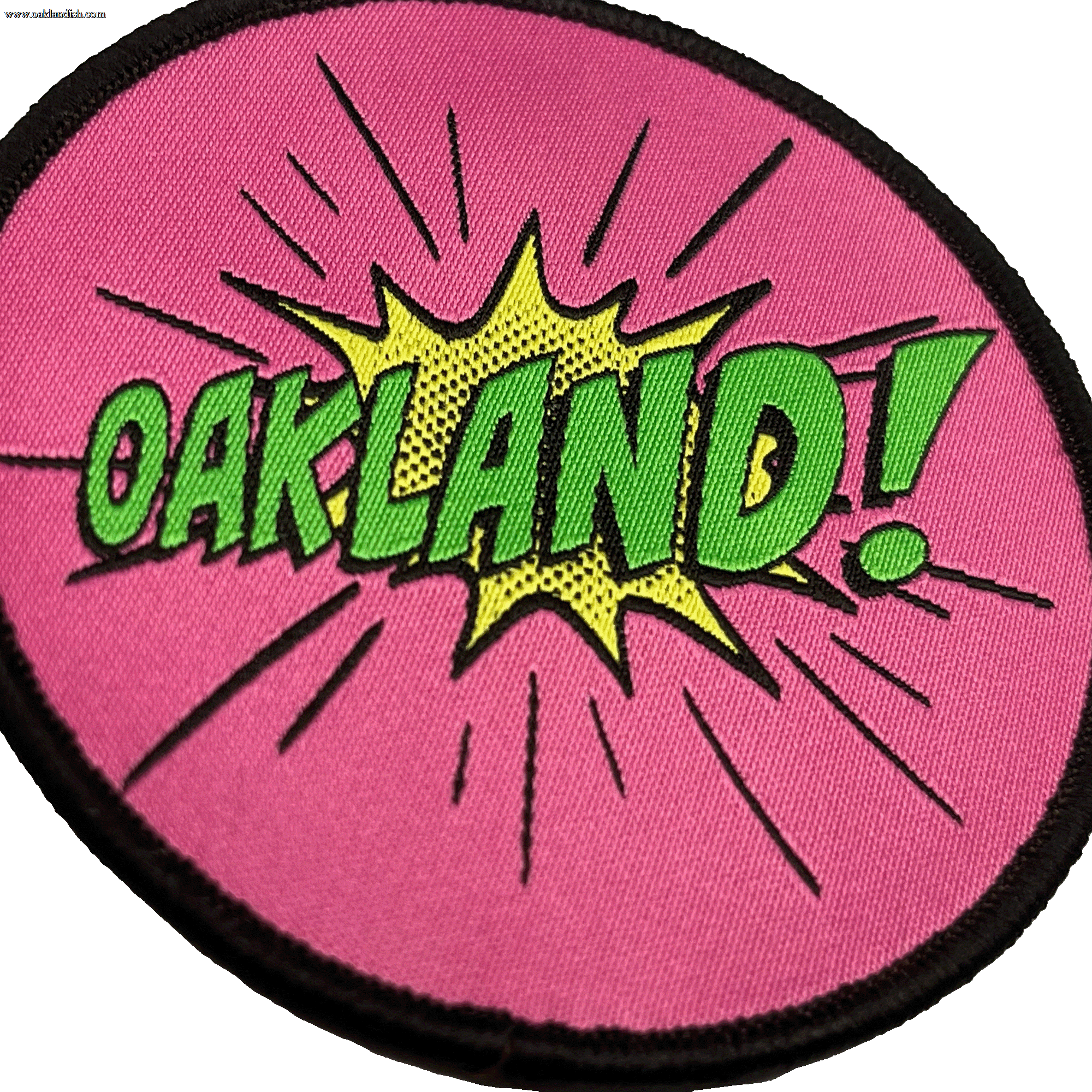 Close-up of embroidered iron-on patch with Oakland wordmark in comic cartoon punch style in pink, green and yellow.