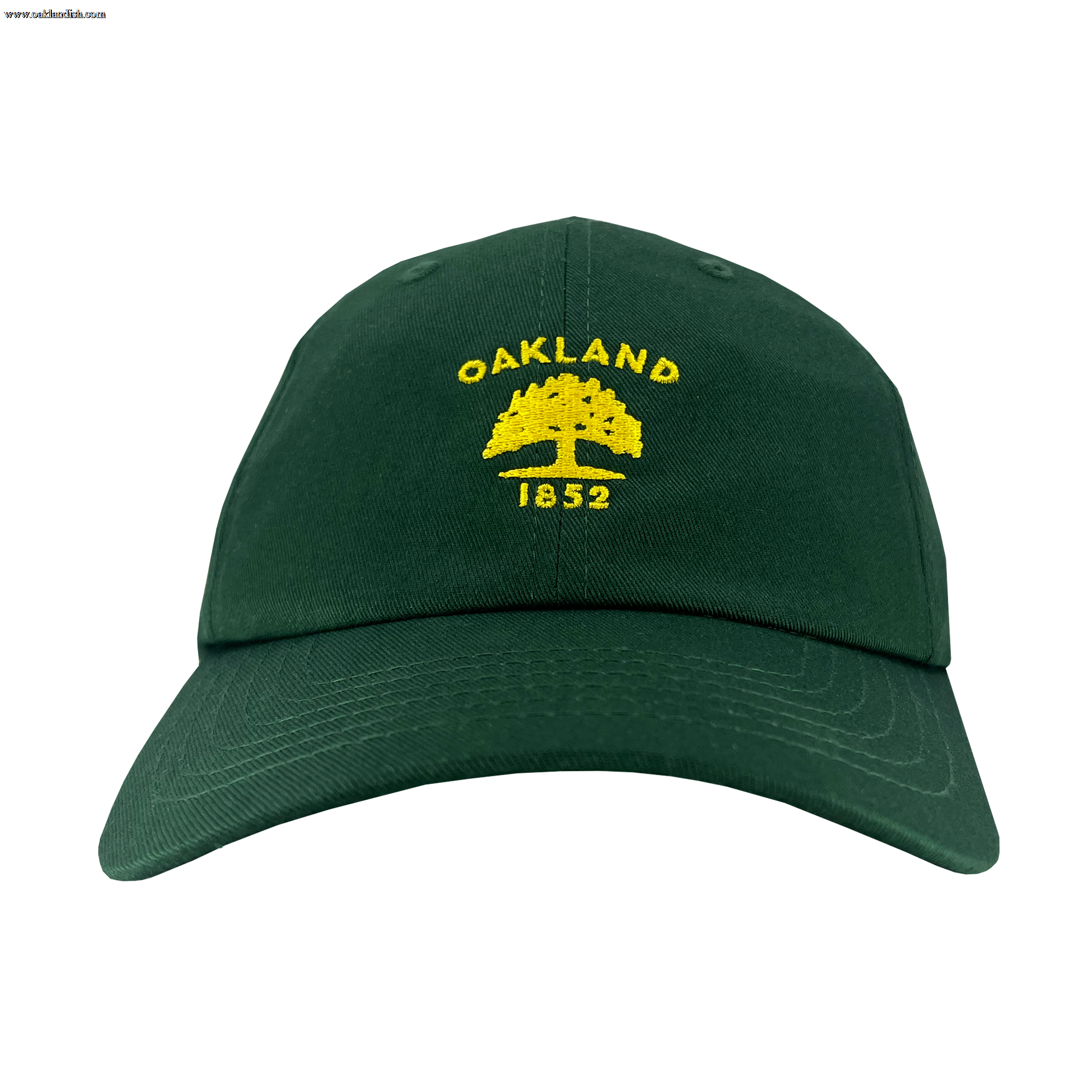 The Oaklandish Oakland Flag Dad Hat is a dark green cap that features the word "OAKLAND" in yellow, arched over an outline of a tree, with the year "1852" written below. The design, inspired by the Oakland flag, is prominently centered on the front. The hat also includes a curved brim and visible stitching.