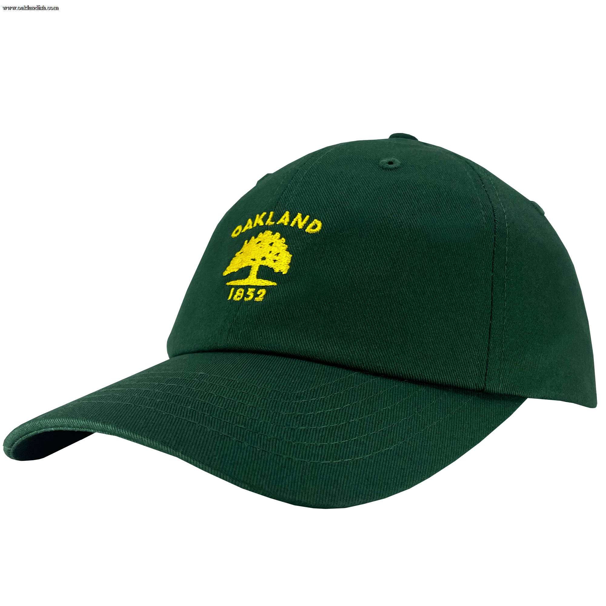 The Oaklandish "Oakland Flag Dad Hat" is a dark green cap adorned with yellow embroidery on the front. The design features the text "OAKLAND" in an arch above an illustrated tree, reminiscent of the Oakland flag, with "1852" below. The hat has a curved brim and an adjustable strap at the back.