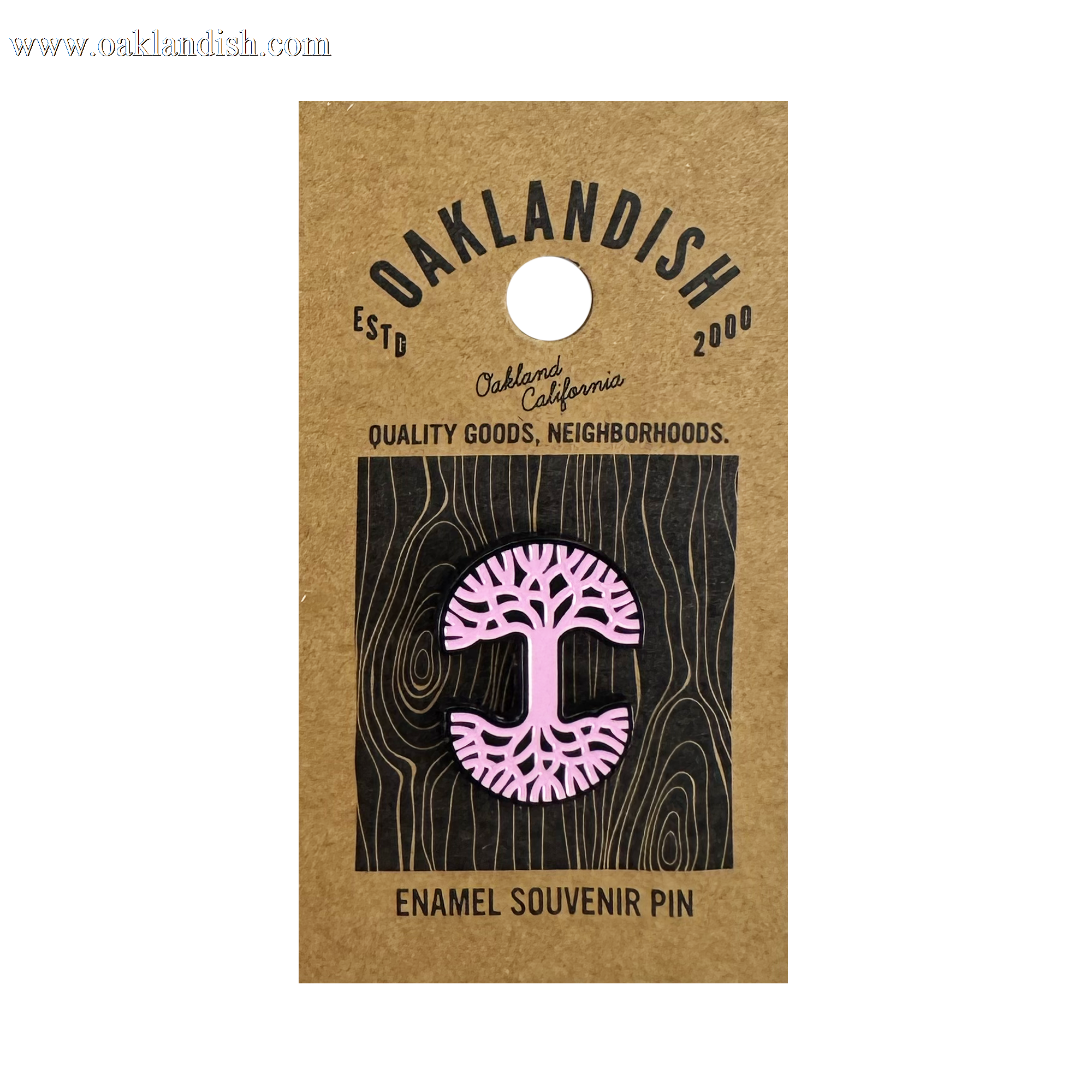The Oaklandish Logo Enamel Pin is a pink enamel accessory shaped like a stylized tree with exposed roots, attached to a brown Oaklandish card labeled “Oakland, California,” “ESTD 2000,” and “Quality Goods, Neighborhoods.”.
