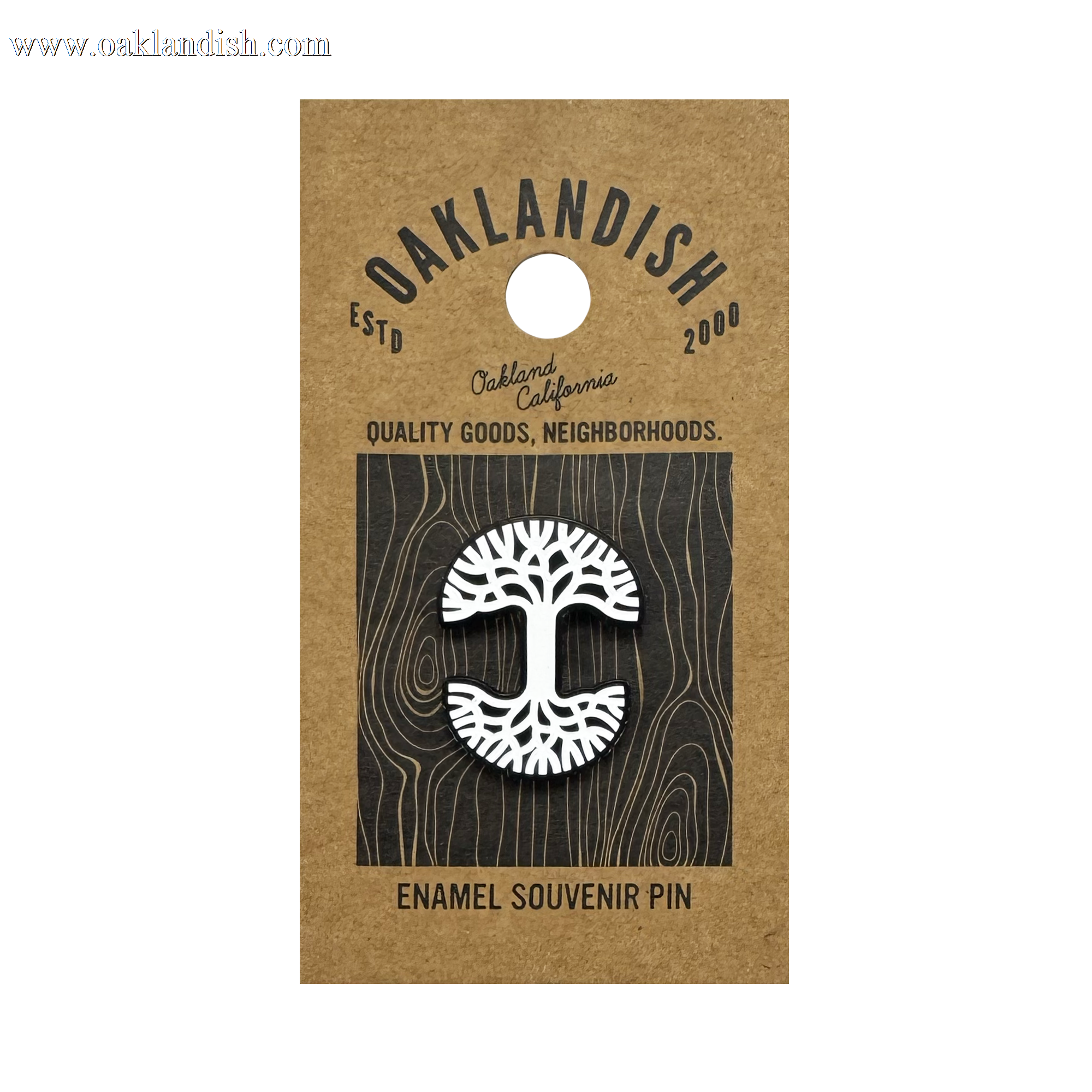 The Oaklandish Logo Enamel Pin by Oaklandish is a white enamel lapel pin shaped like an oak tree, attached to brown kraft paper backing and featuring text: “OAKLANDISH ESTD 2000,” “Oakland California,” and “ENAMEL SOUVENIR PIN.”.