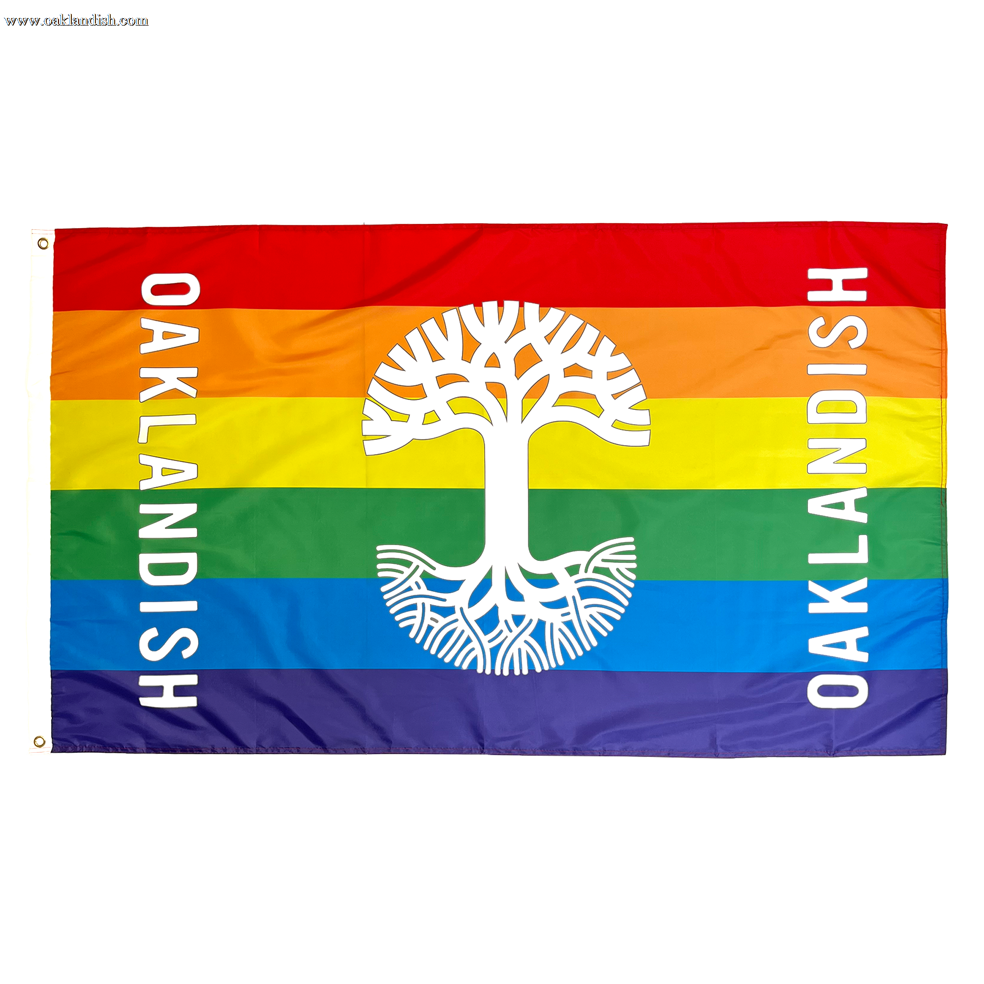 The Oaklandish Pride Logo Flag, crafted by Oaklandish, features a rectangular design with horizontal stripes in the rainbow colors: red, orange, yellow, green, blue, and purple. At the center is a white stylized tree. "OAKLANDISH" is written vertically in white on both sides of this knit polyester flag—a perfect accessory for any space.