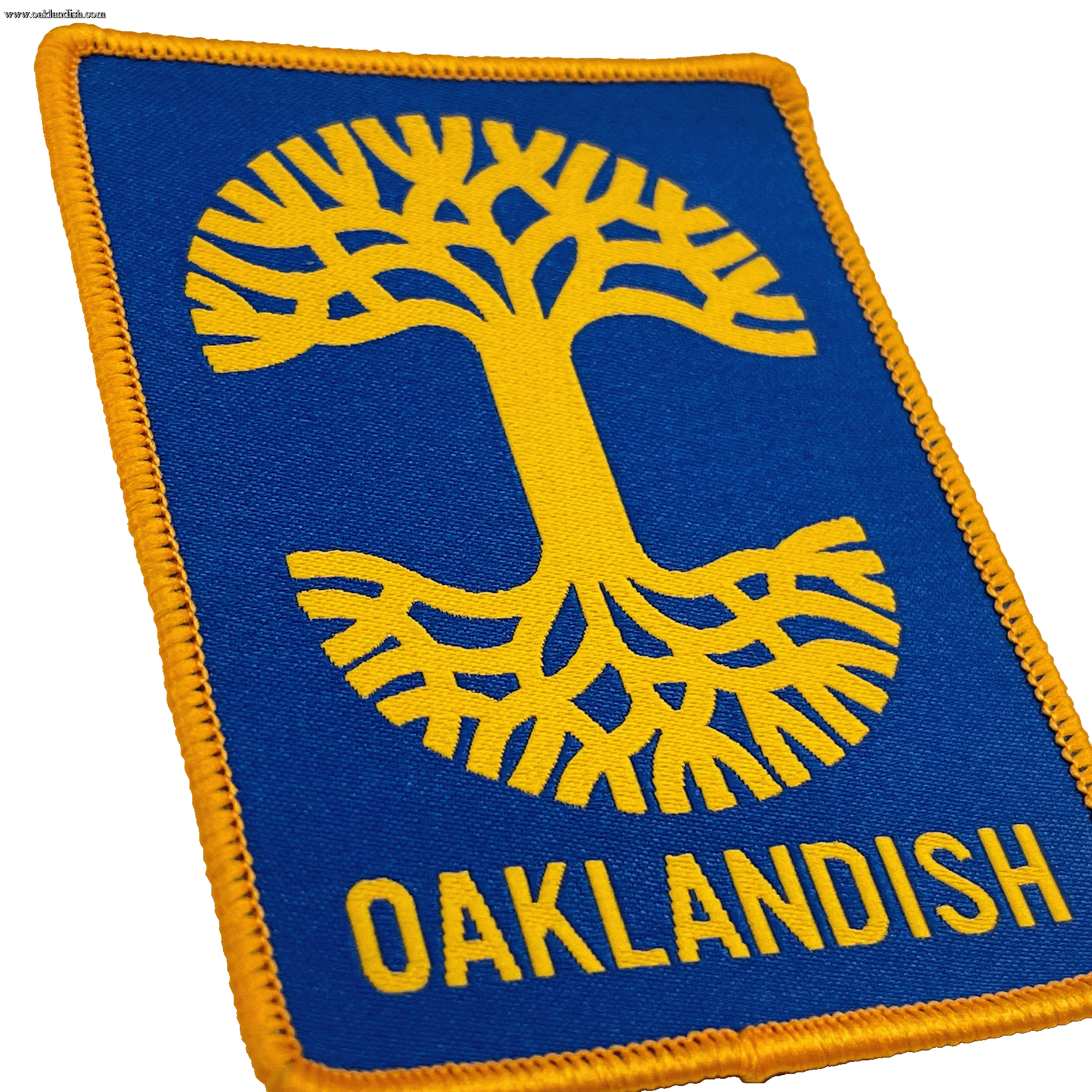 Close-up of royal blue woven iron-on patch with gold Oaklandish tree logo and wordmark.