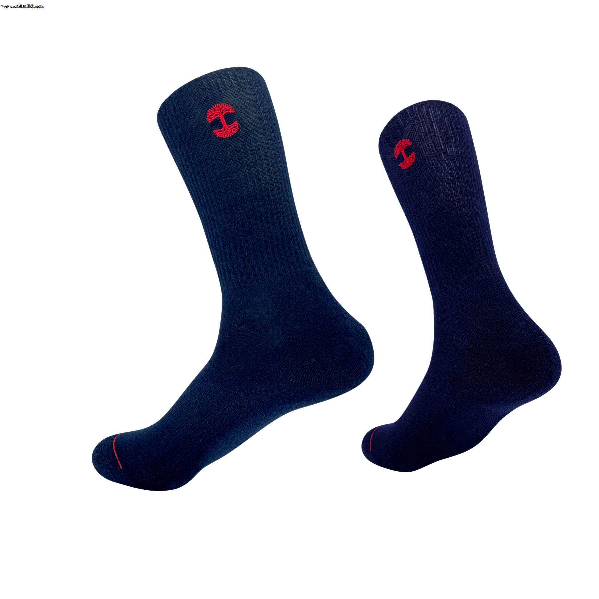 An image of the Embroidered Logo Sock by Oaklandish features two dark blue crew socks, each adorned with a red embroidered Oaklandish logo near the top. The socks are positioned upright with toes slightly pointed downward, creating a floating appearance against a white background. The adult-sized socks also have ribbed cuffs and a red accent line near the toes.