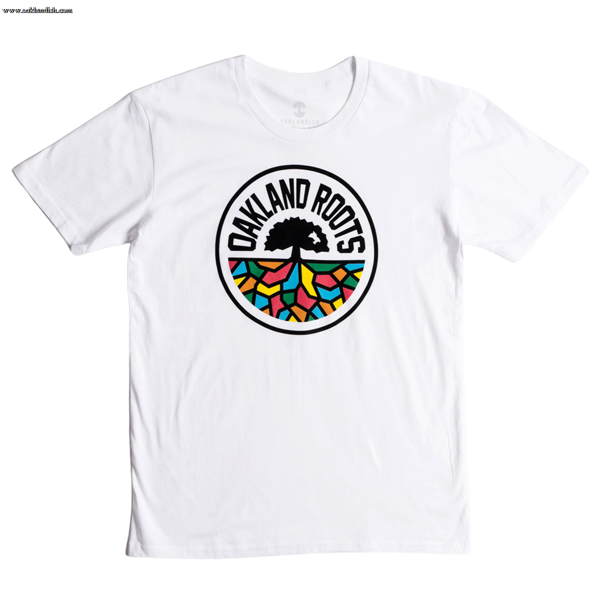 The Oakland Roots SC Classic Tee from Oakland Roots SC showcases a striking circular logo in the center. At its heart is a black tree with sprawling roots, accompanied by the text "Oakland Roots" elegantly arched above it. The roots branch out into vibrant sections of red, blue, green, and yellow, forming a stained-glass effect that symbolizes the club's commitment to social good.