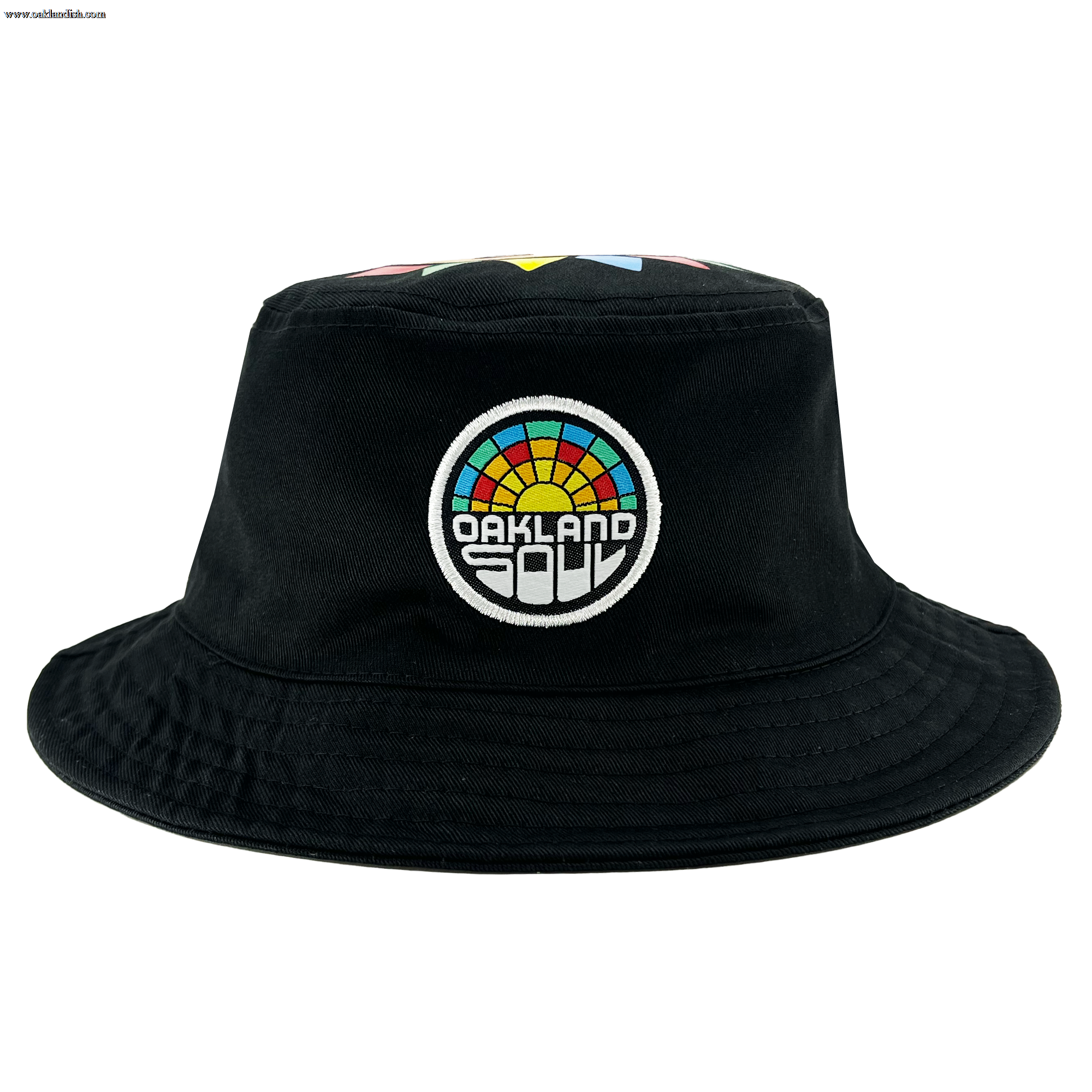 Introducing the Oakland Soul & Roots SC Reversible Bucket from Oakland Roots SC—a stylish black bucket hat that boasts a vibrant embroidered patch on the front. The circular patch features a rainbow of colors and displays the words "OAKLAND SOUL" within it. With its wide brim and robust, simple fabric, this hat offers both casual elegance and sturdy functionality.