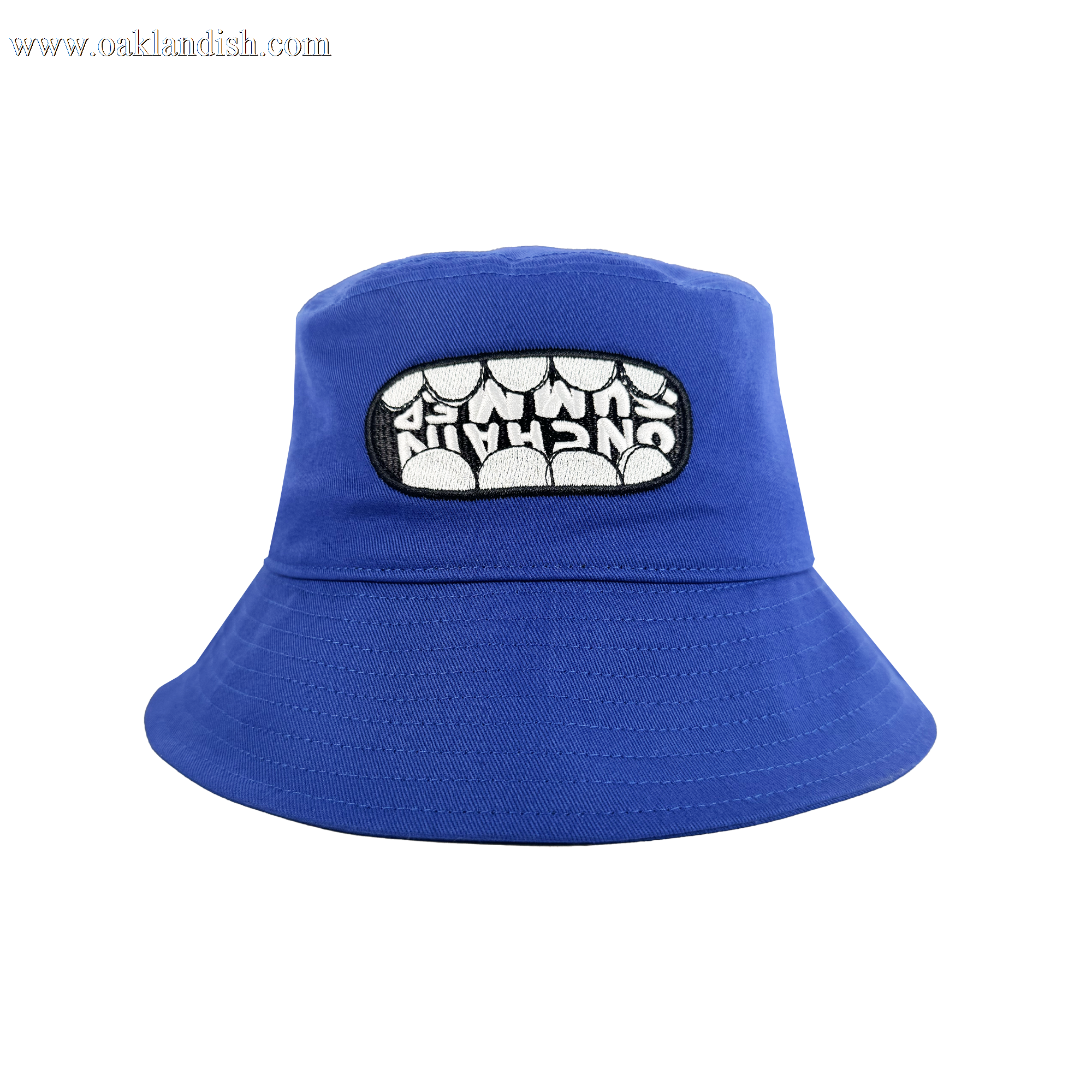 The OG Bucket Hat by Supported Brands is a bright blue hat with a front patch showing bold "UNCHAIN" lettering across white teeth. Ideal for Onchain Summit style or pairing with your favorite OG enamel pins.