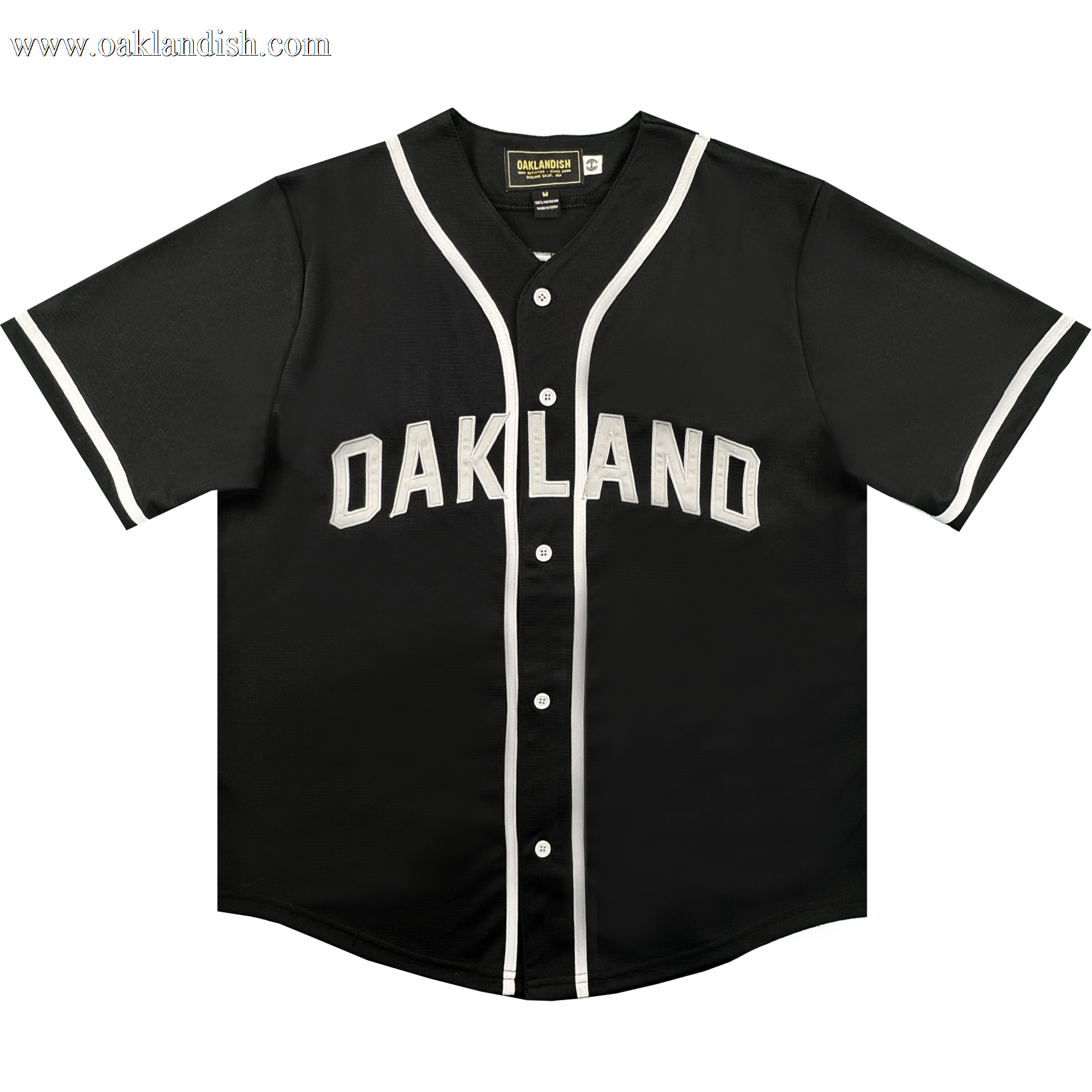 Here’s a rewritten sentence using your product data: The ORSC Button Up Jersey by Oakland Roots SC is a black short-sleeve baseball jersey with white trim on the sleeves and collar, featuring "OAKLAND" in bold white letters across the chest. Inspired by the Oakland Roots Sports Club, it includes white buttons down the front and a black tag at the inside collar.
