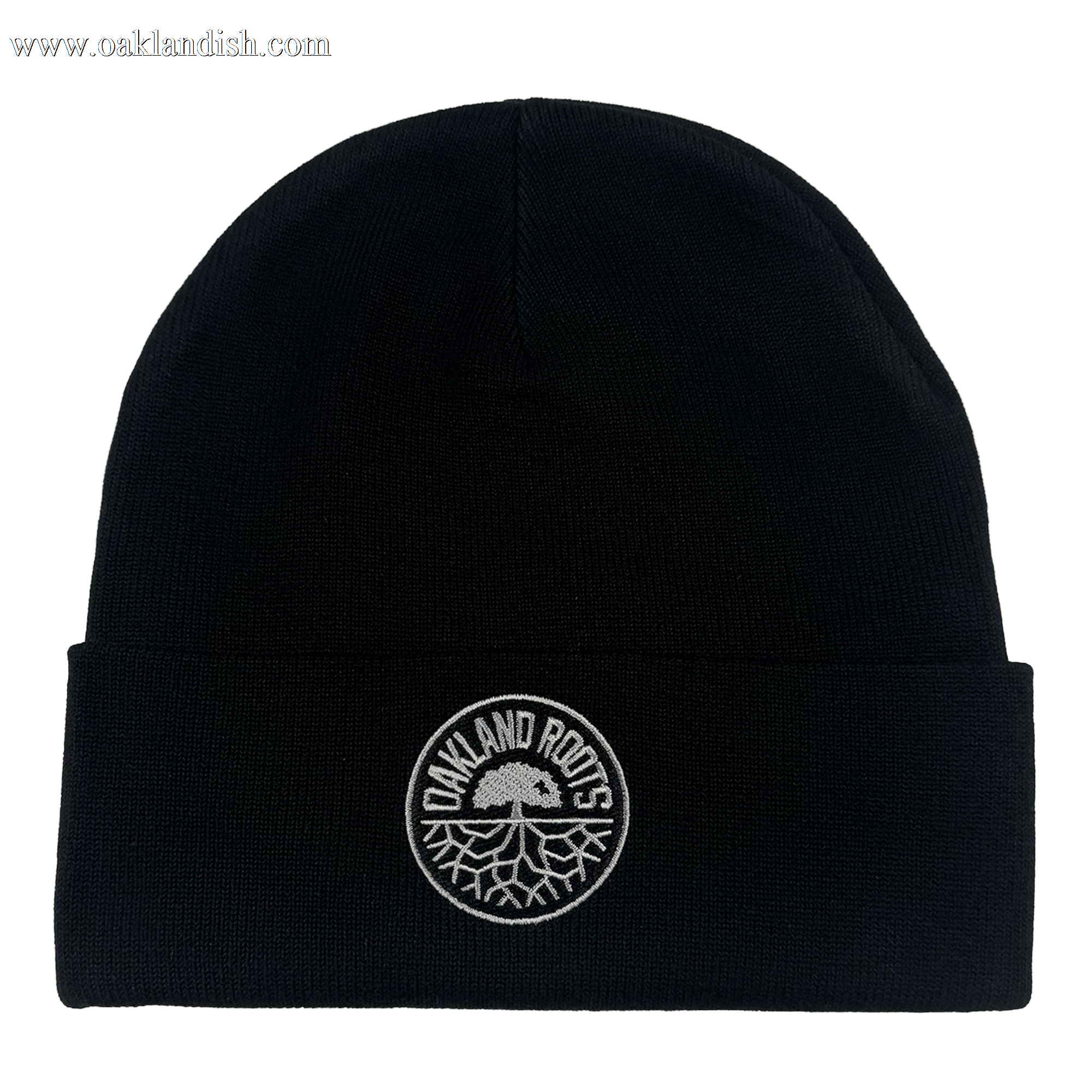 The ORSC Beanie by Oakland Roots SC is a black knit hat with a folded brim and a circular white patch on the front featuring "OAKLAND ROOTS" and the club’s tree logo. The background is plain white.