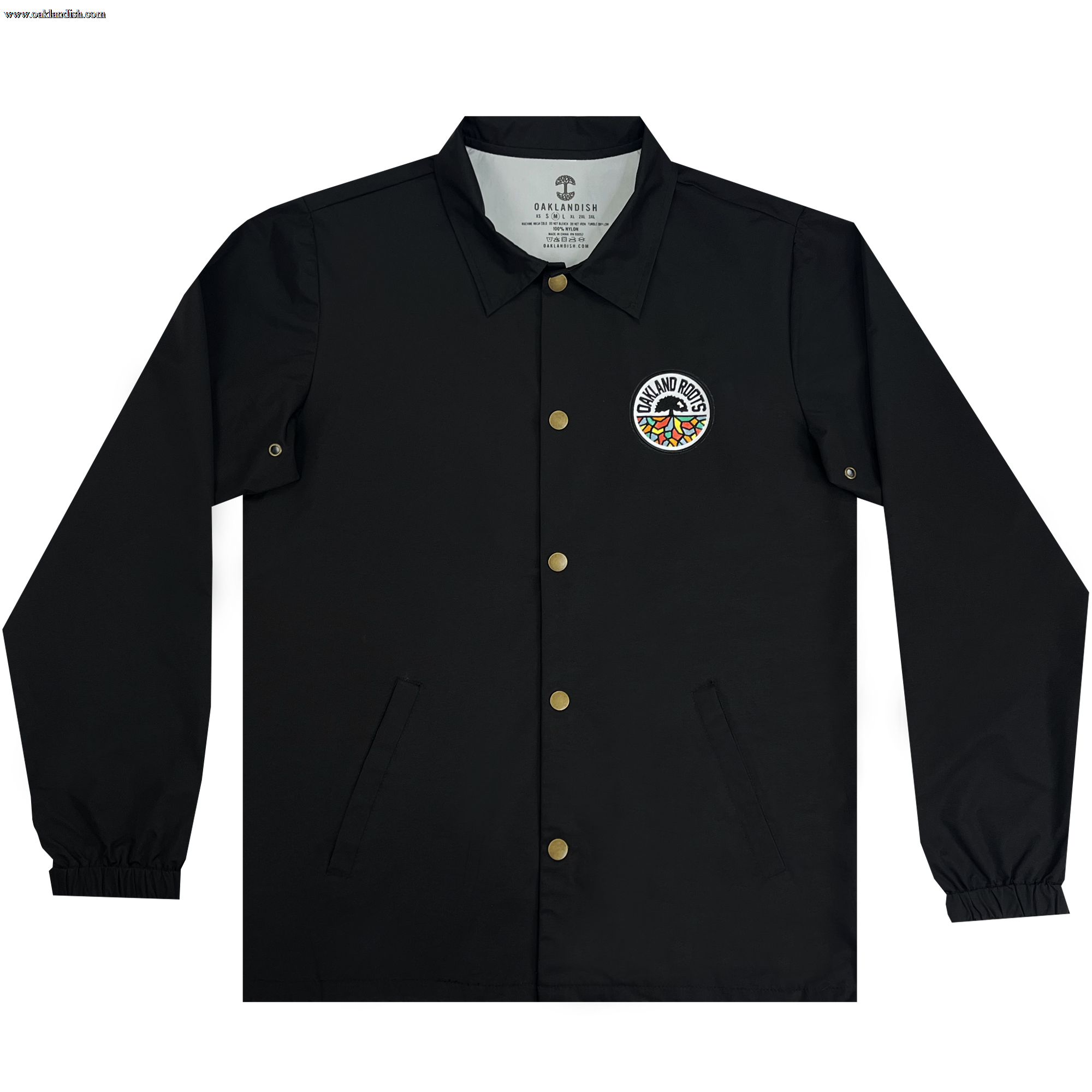 The Oakland Roots SC Coaches Jacket by Oakland Roots SC is showcased. This black, water-resistant premium jacket has gold snap buttons, a collar, elastic cuffs, and a logo patch on the left chest area. The circular logo reads "Grand Rhythm" surrounding a colorful design. The interior tag states "Grand Rhythm" and "Diamond Supply Co.