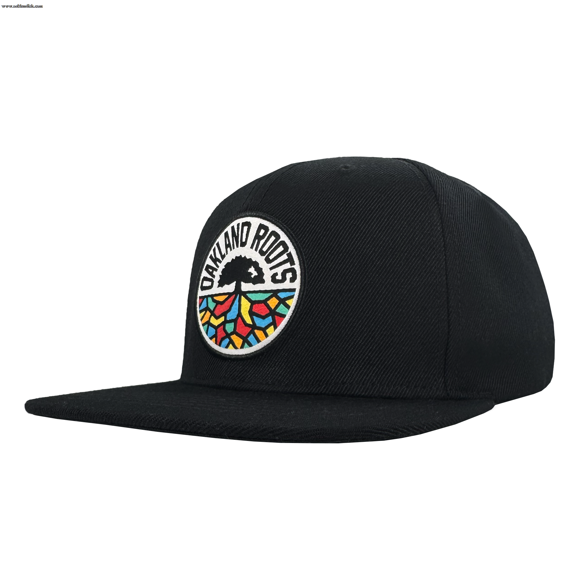 The Oakland Roots SC Structured Snapback is a black flat-brim cap with a round front patch showing "OAKLAND ROOTS," a black tree, and colorful root patterns—ideal for any passionate Oakland Roots SC supporter.