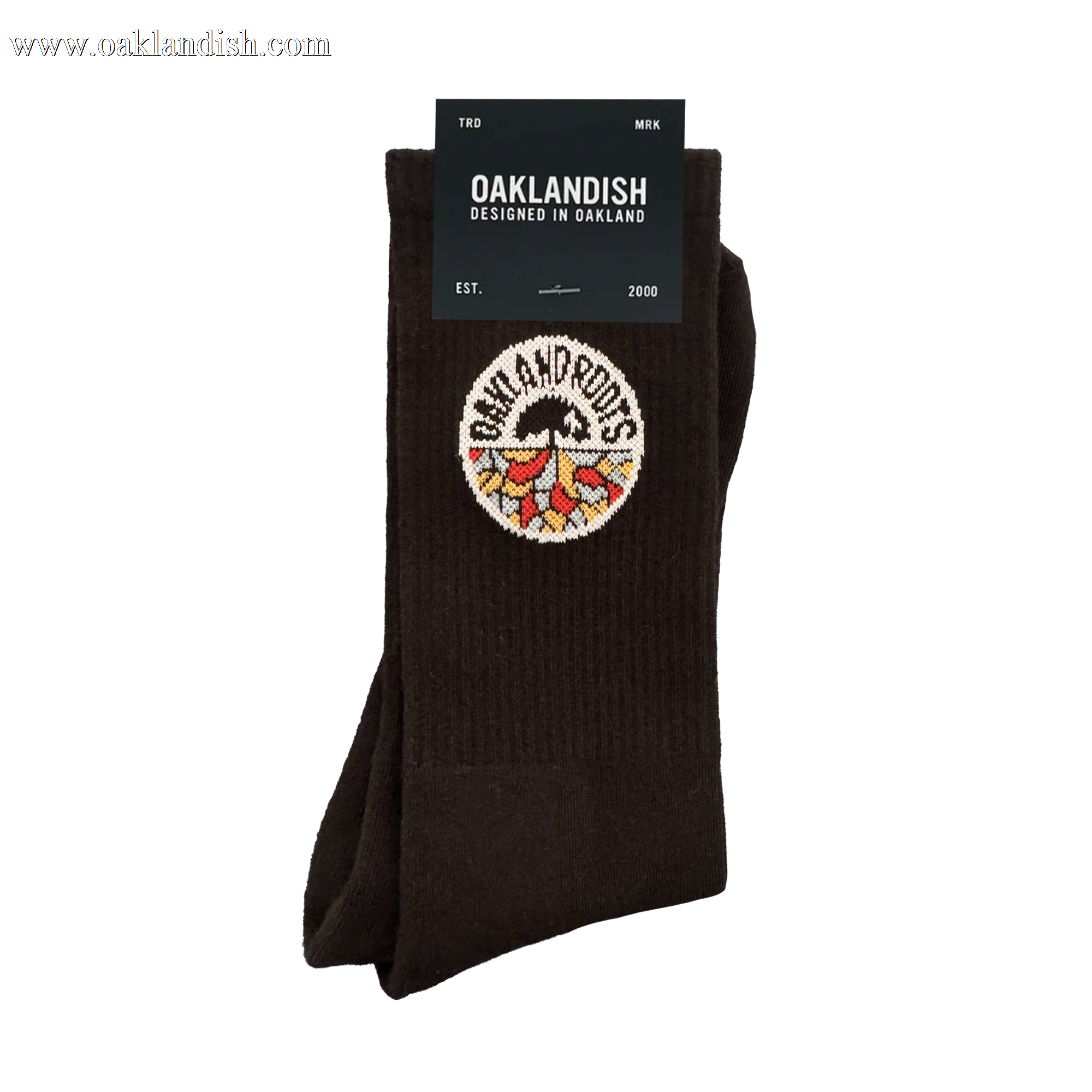 The Roots SC Socks by Oakland Roots SC are black cotton crew socks with a colorful tree and roots embroidered patch. The label reads "OAKLANDISH Designed in Oakland," “one size fits most,” and includes "EST. 2000" on the packaging.