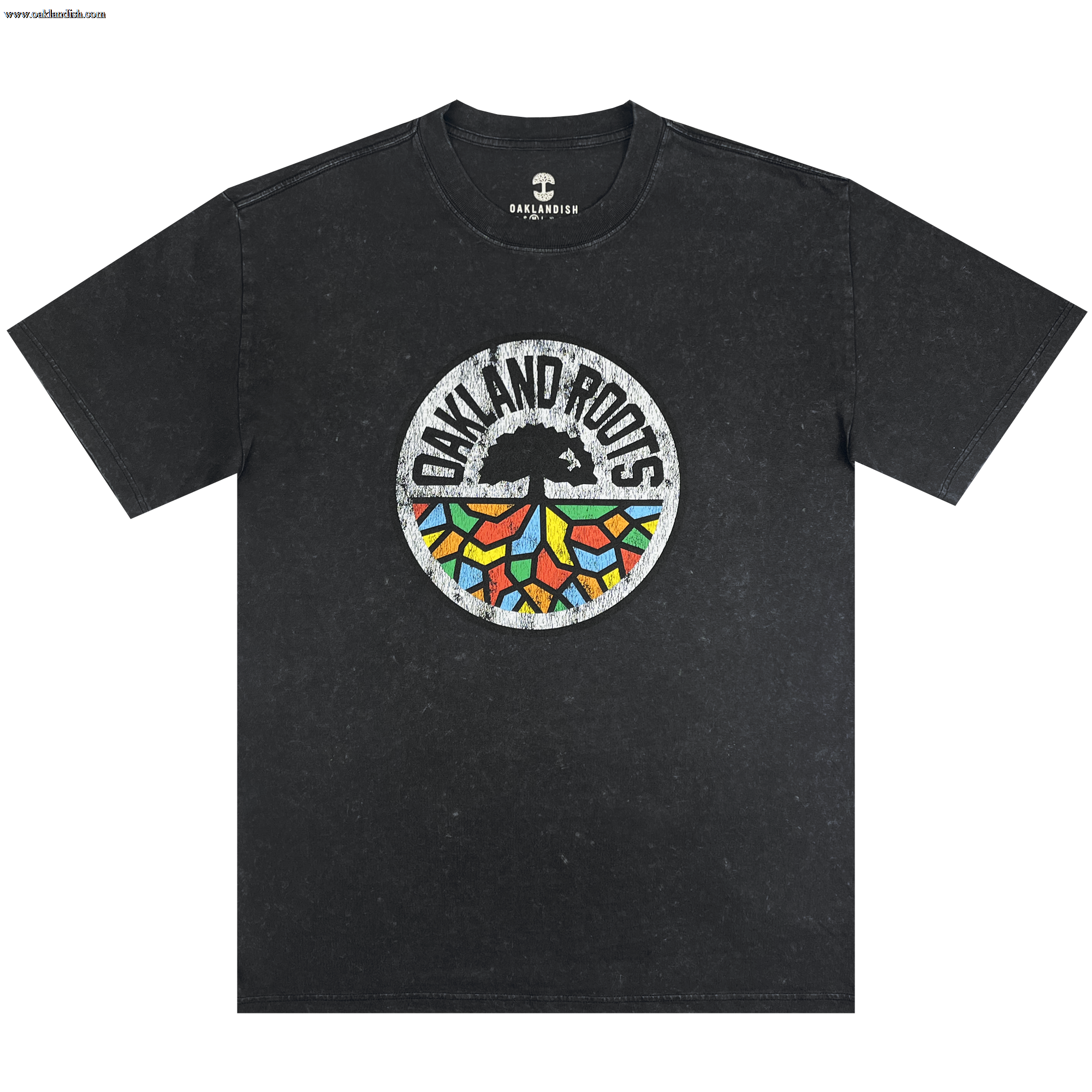 The Oakland Roots SC Classic Heavy Stone Wash Tee is a black, short-sleeved T-shirt that features a central circular logo. The logo showcases an abstract tree design with vibrant, geometric leaves and the text "Oakland Roots" arched above it, symbolizing the sports club's dedication to social good. The Oaklandish brand logo is printed near the collar for an added touch of authenticity.