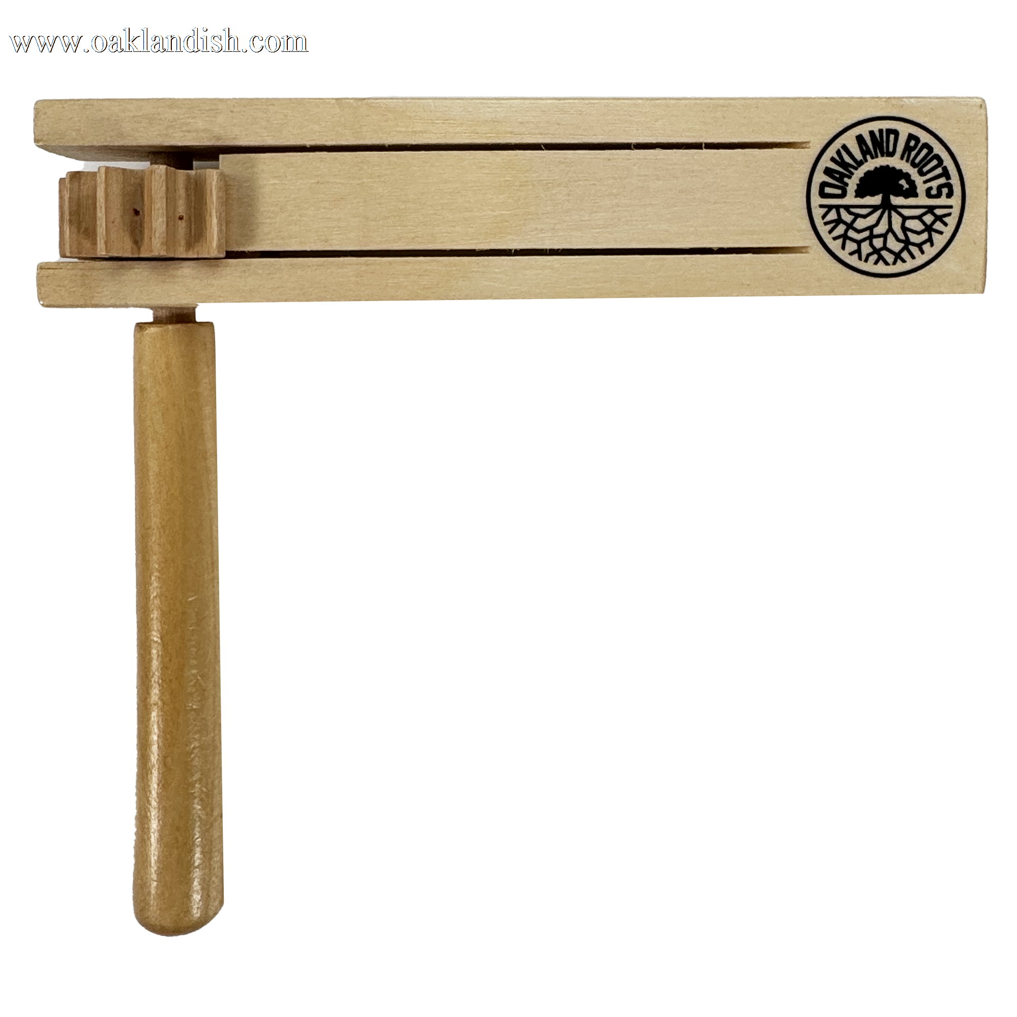 The Oakland Roots SC Matraca is a wooden noisemaker featuring the Oakland Roots SC logo with bold text and a striking tree graphic. It includes a handle, rotating mechanism, two horizontal slats, and gear-like parts for sound, embodying Oakland's spirit.