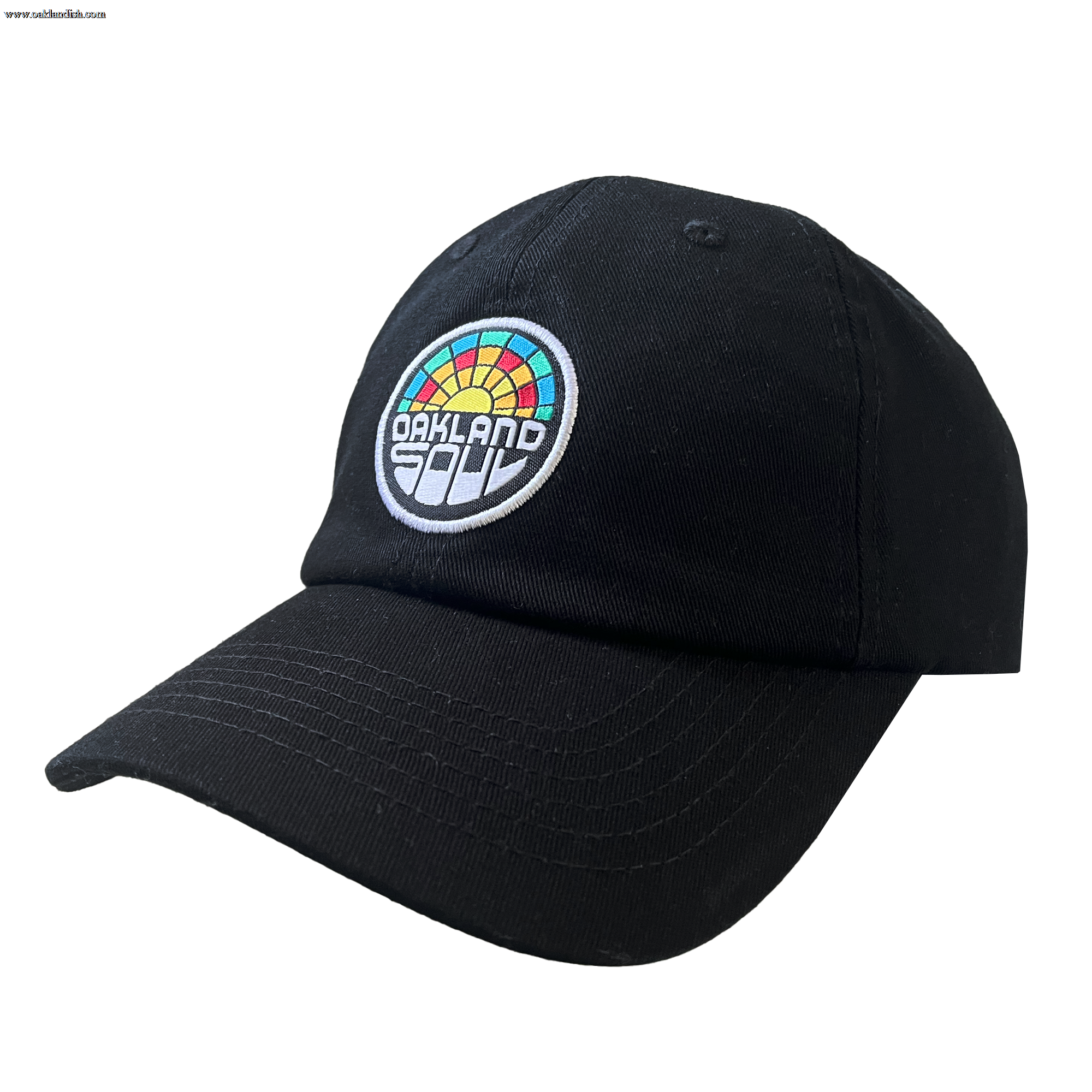 The Oakland Soul Dad Hat is a black baseball cap adorned with a multicolored circular patch on the front. The patch showcases the text "OAKLAND" in white and "SOUL" in black, set against a rainbow design featuring red, orange, yellow, green, and blue segments. This cap celebrates the Oakland Soul women's soccer team in the USL W-League.