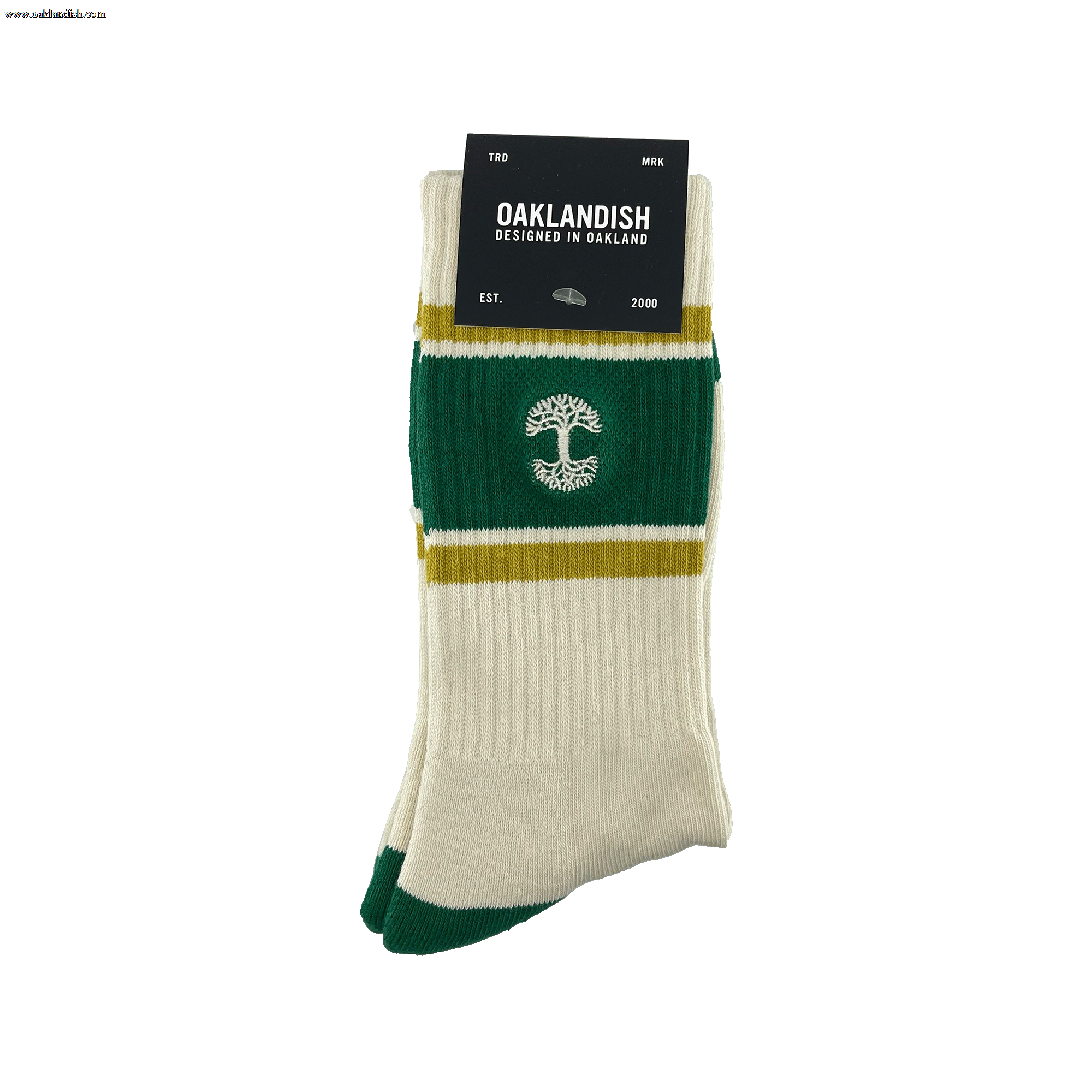 A brand new pair of Striped Classic Socks from Oaklandish, designed in a cream and green color palette with mustard yellow stripes, is neatly folded and adorned with a black cardboard tag. Made from 70% cotton, these crew socks feature a distinctive white tree emblem in the center. The tag reads "Oaklandish, Designed in Oakland," followed by "EST." and "2000." They are presented against a white background.