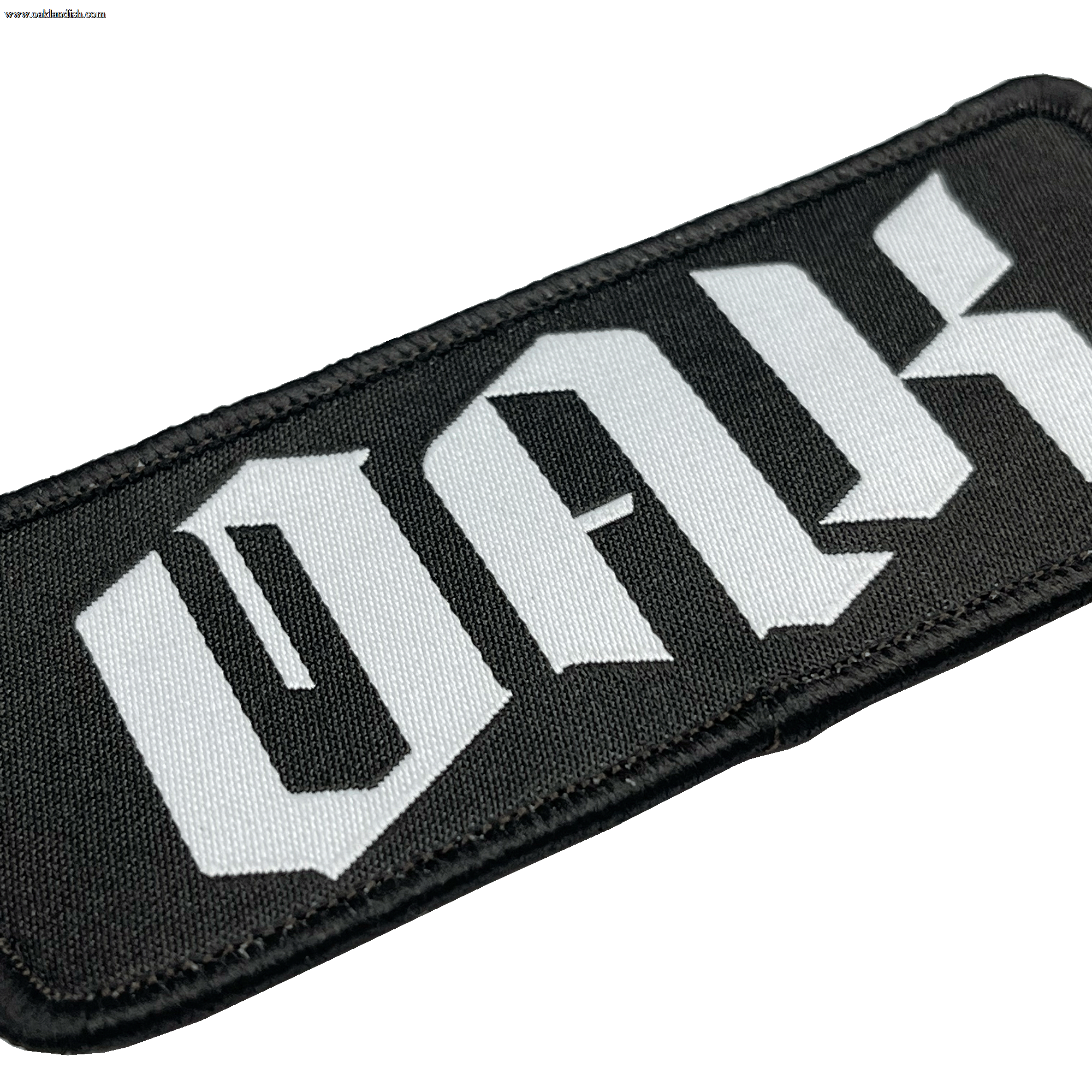 A close-up of the OAK Official Patch by Oaklandish, featuring a rectangular black embroidered design with the words "OAK with the drip" in large, stylized white letters. The letters boast a gothic, angular design and the patch's edges are neatly sewn with black thread. The background is plain white.