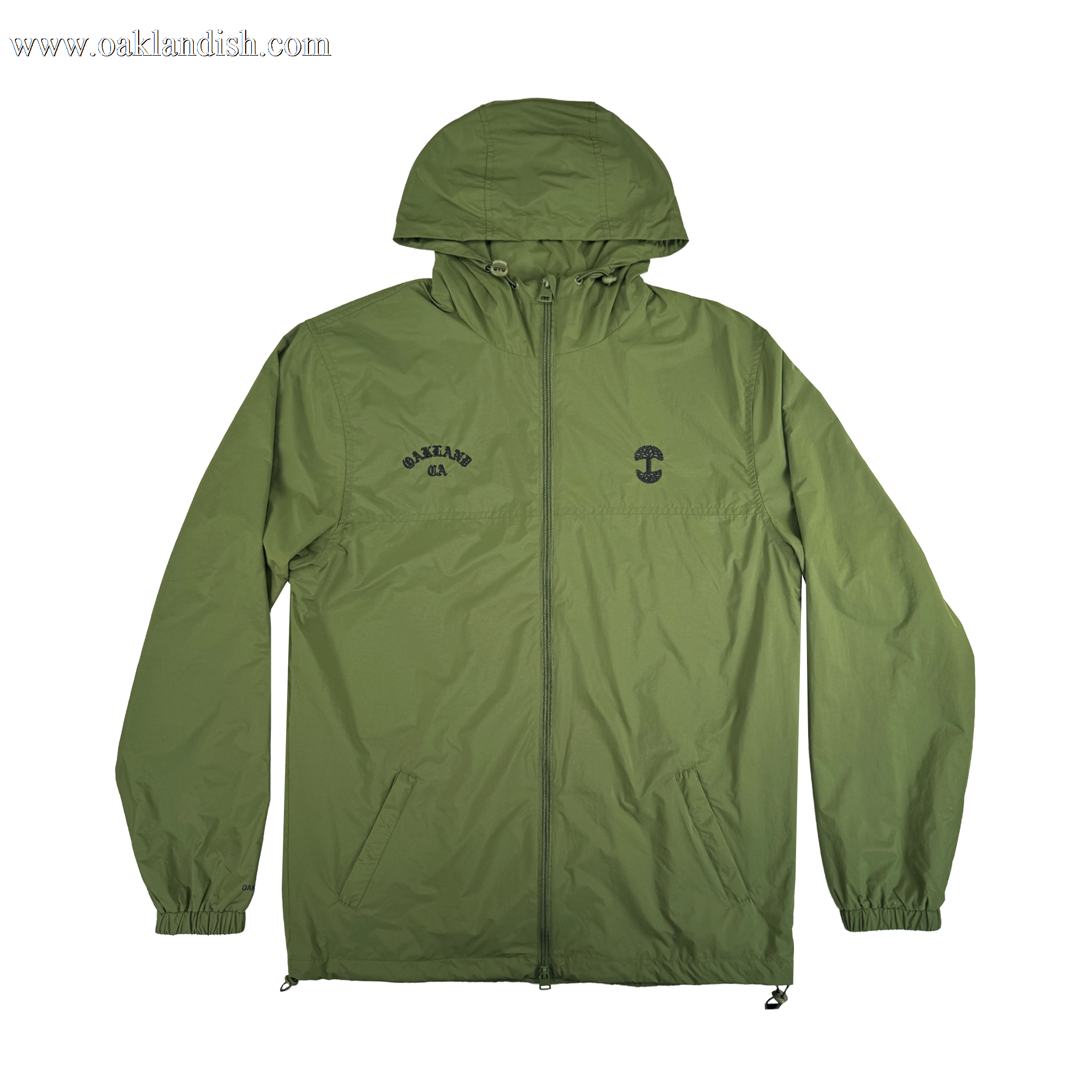 The Oaklandish Susurrus Track Top is a lightweight olive green nylon jacket with a classic fit, hood, front zipper, elastic cuffs, and two side pockets. Features include a small black left-chest graphic and "CAKELAND" logo on the right.